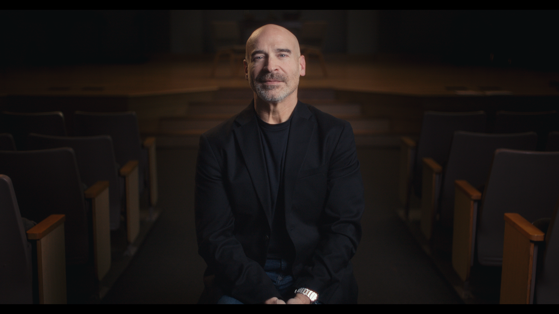 Kent Callison sitting in front of a stage