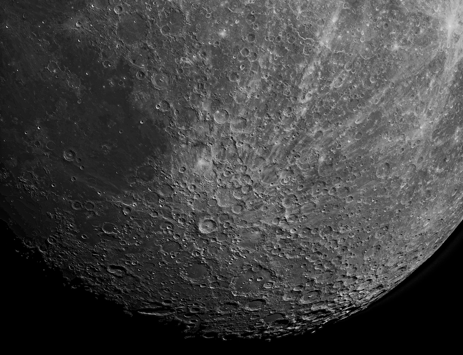 Close-up black and white view of the moon's cratered surface.