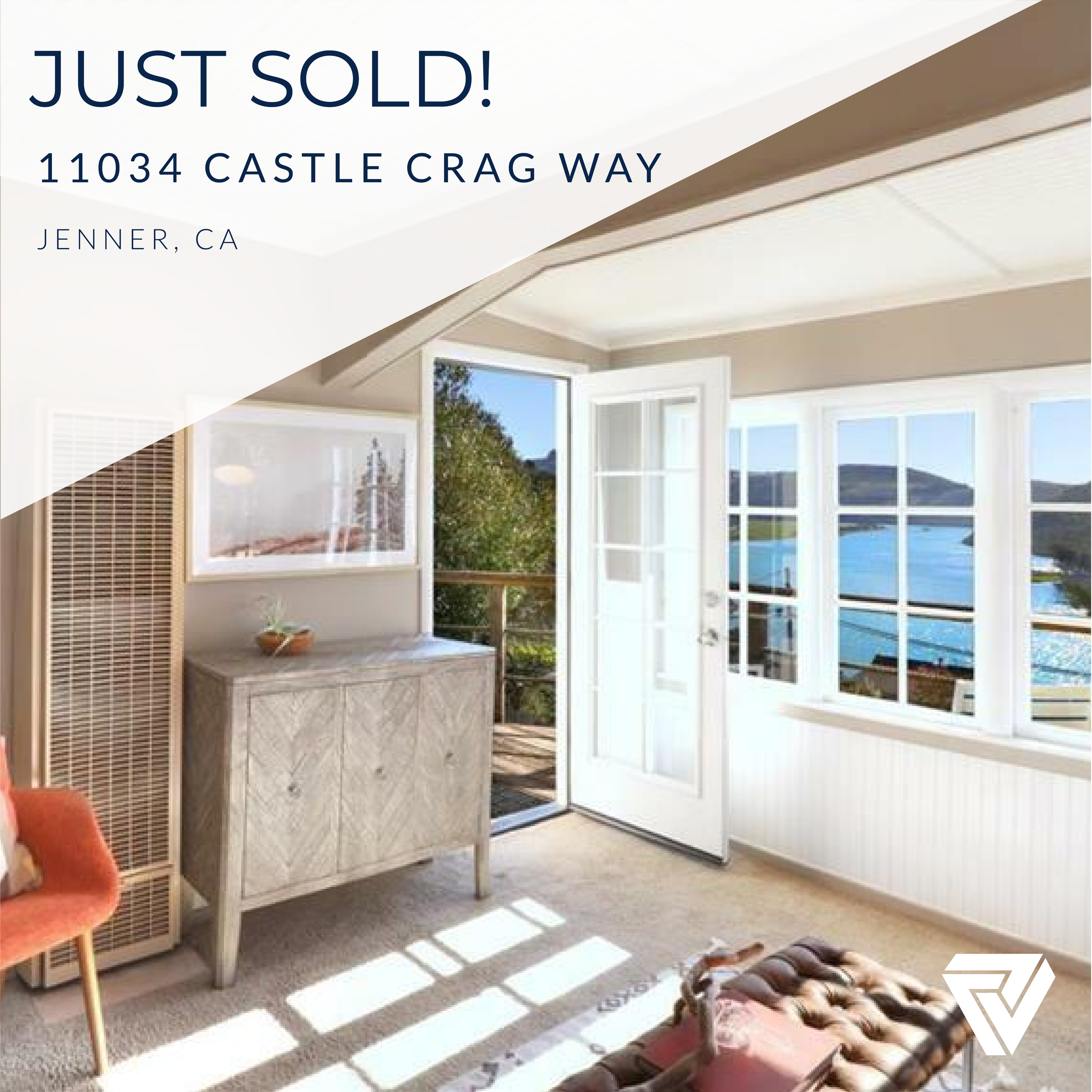 Bright living room with windows overlooking water and hills, open door to balcony, and modern furnishings.