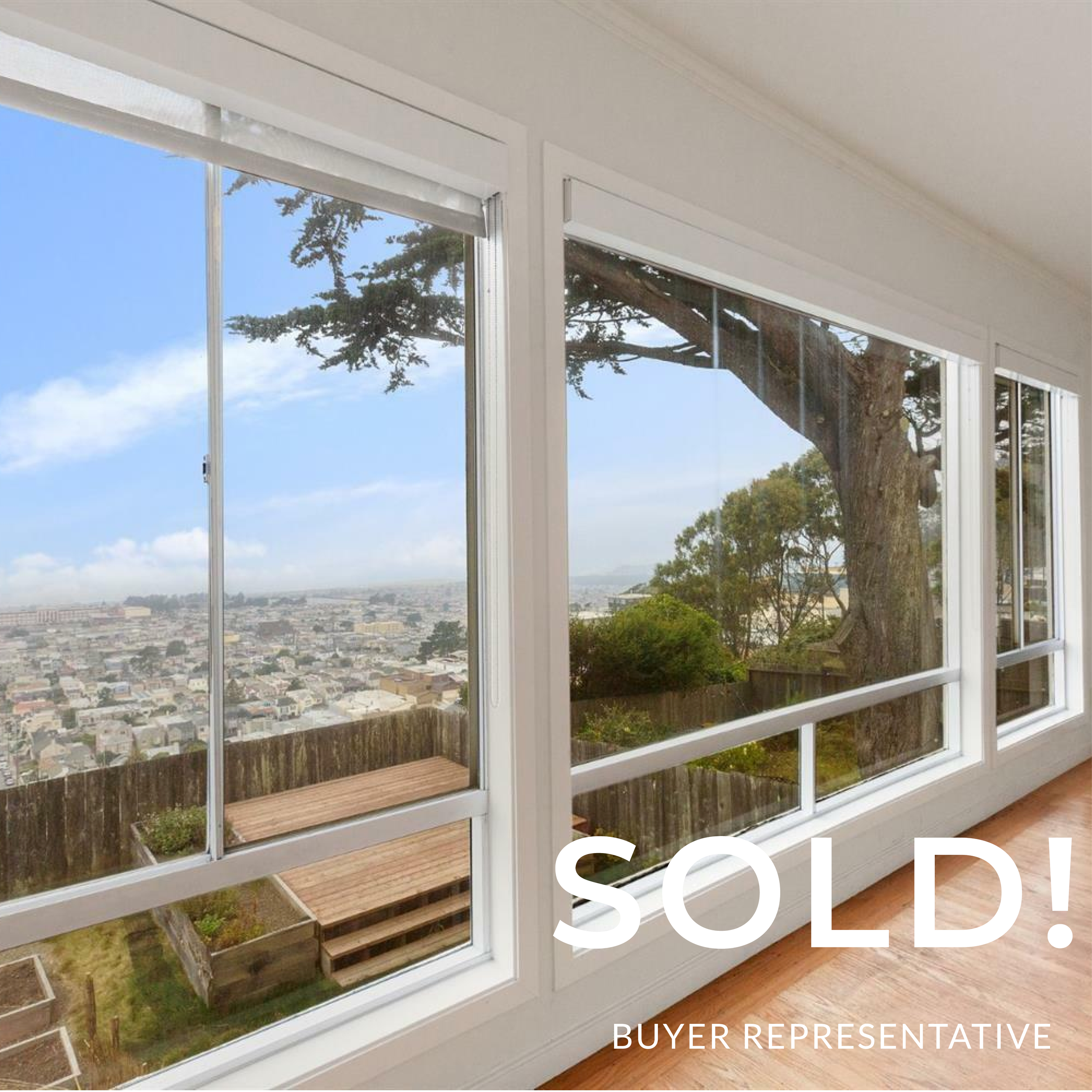 Interior view of a house with large windows overlooking a cityscape, trees, and a deck outside. The word 'SOLD!' is overlaid on the image, indicating a real estate sale.