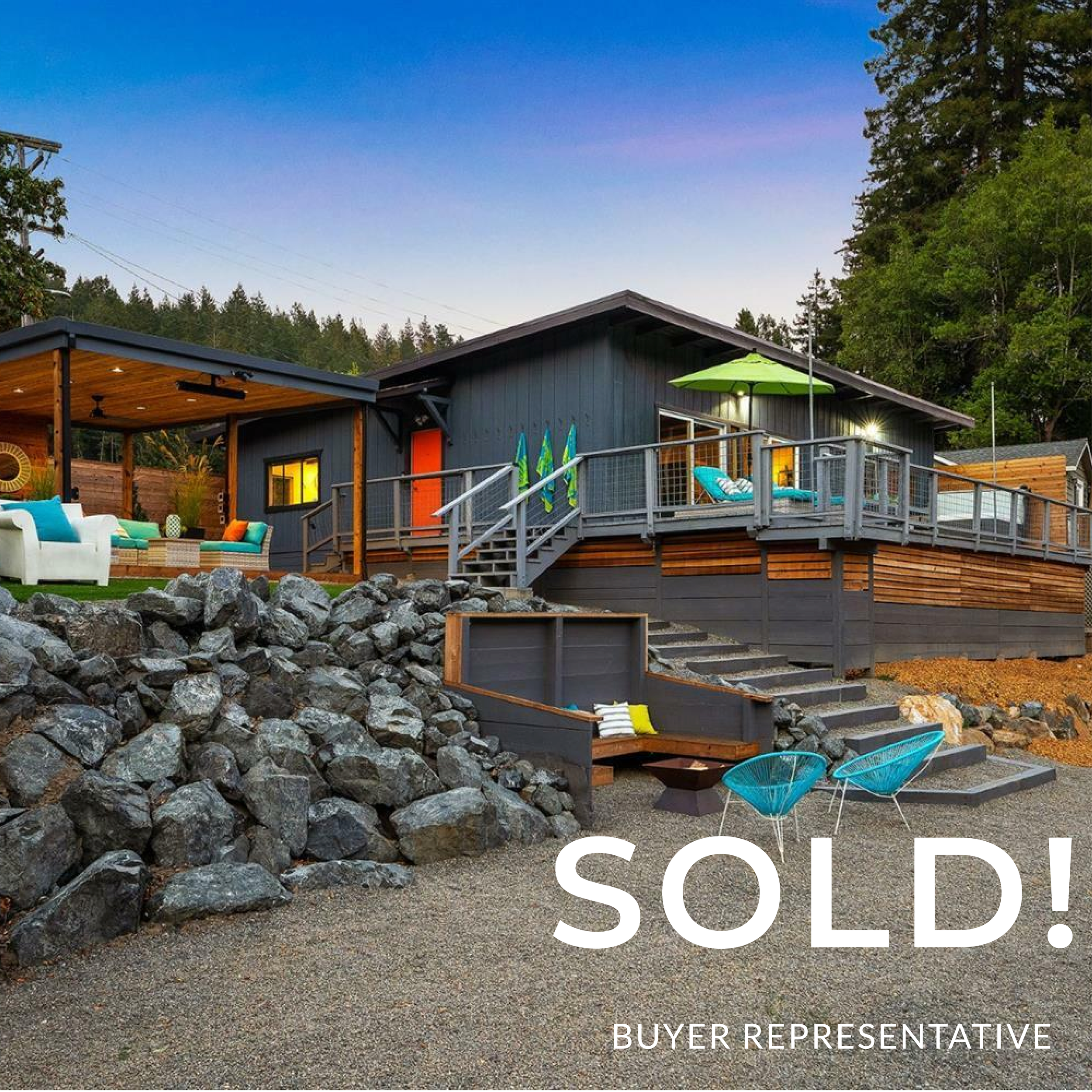 A modern, multi-level house with an outdoor deck and seating area, surrounded by rocks and trees, sold by a buyer representative.