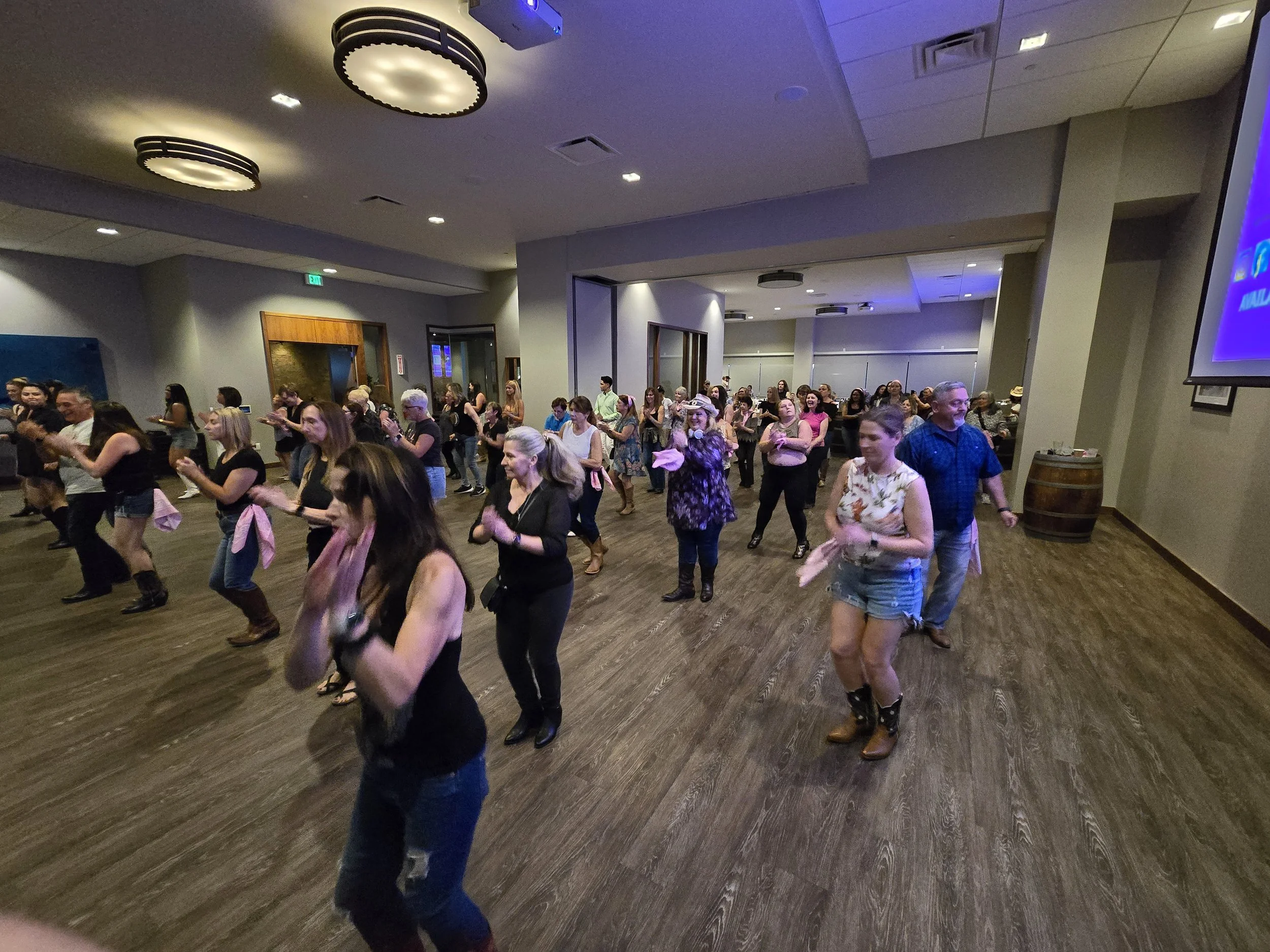People line dancing in at Pinstripes San Mateo with wood floors and modern ceiling lights. A DJ Shivers and Line Dancing Lisa public event held 1 Friday per month.