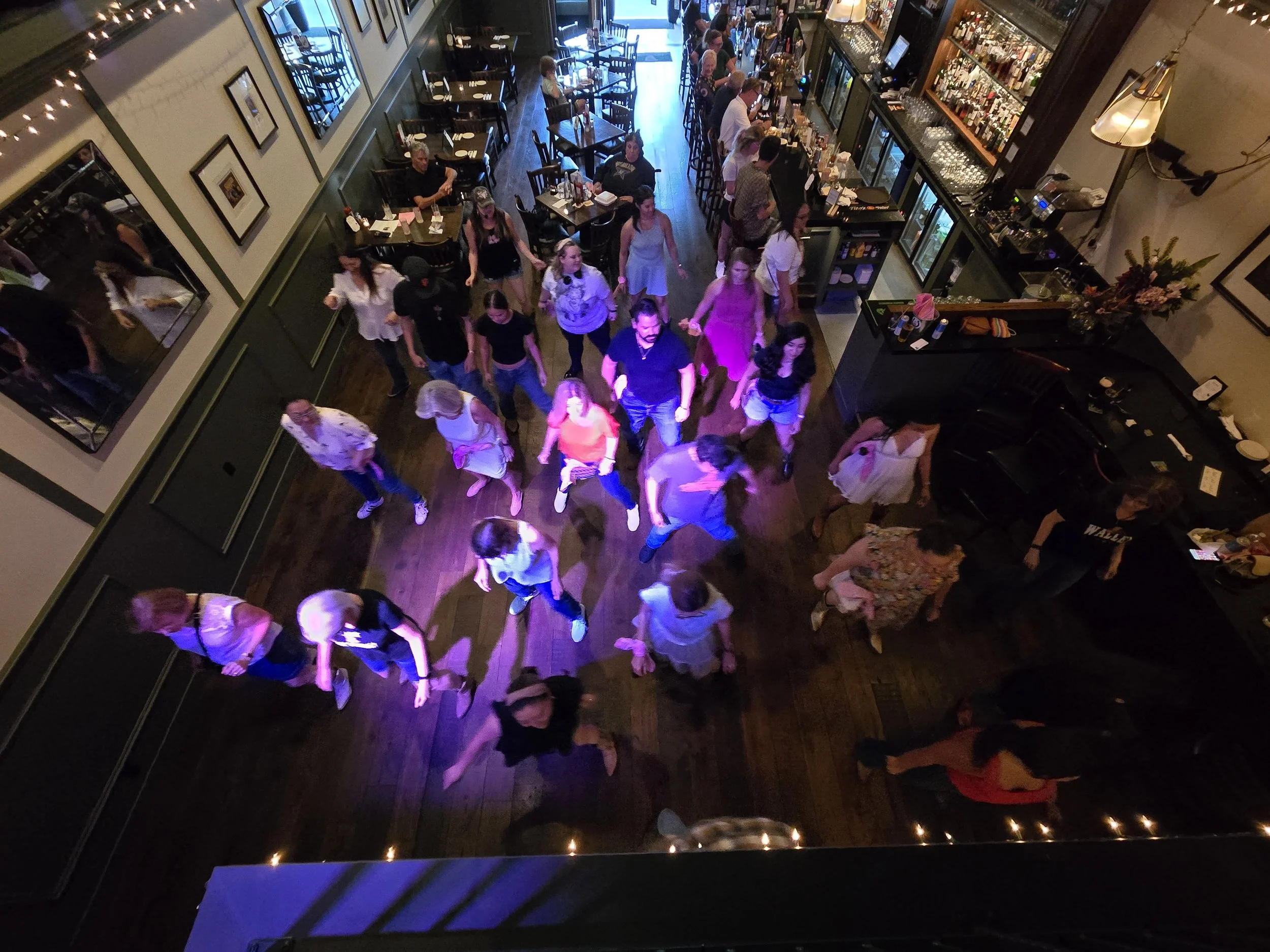 Line Dancing Lisa and DJ Shivers with a public event at Molly O's in San Carlos. People dancing and socializing in a lively restaurant or bar with tables, chairs, and a bar counter.