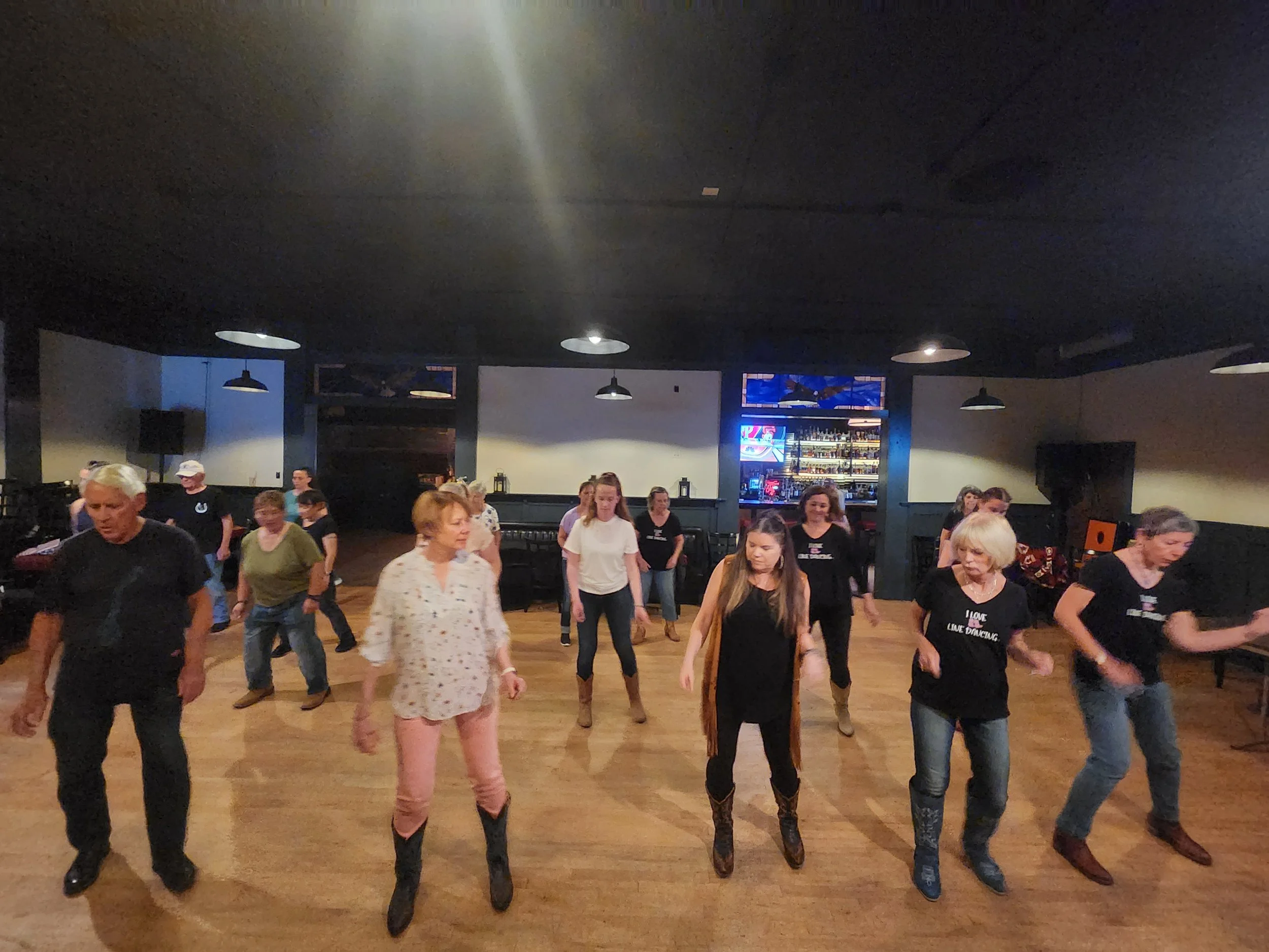 Crowd line dancing at a DJ Shivers country dance event in the San Francisco Bay Area with high-energy music and guided instruction.