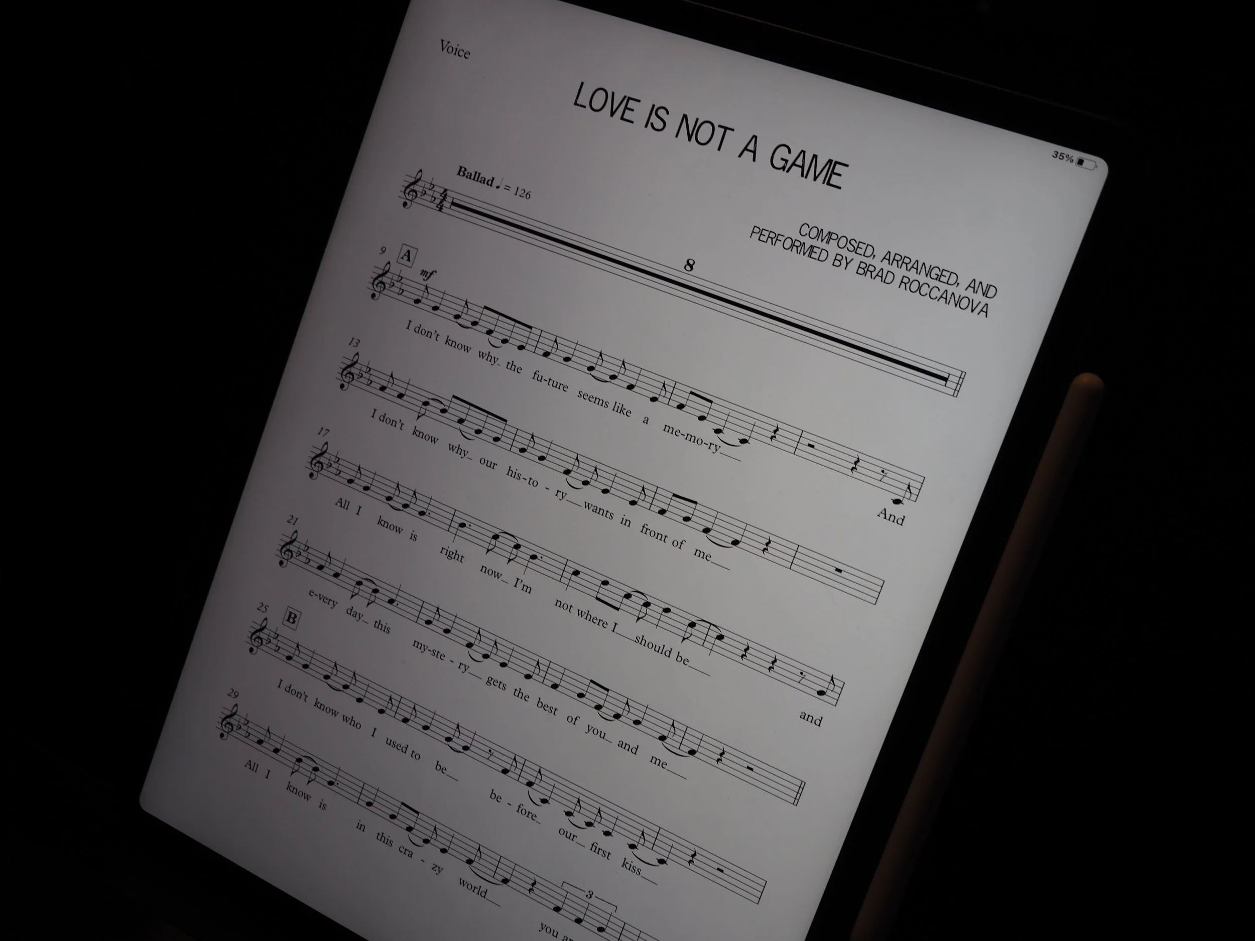 Music sheet titled "Love Is Not a Game" with musical notes, lyrics, and song details displayed on a tablet screen.