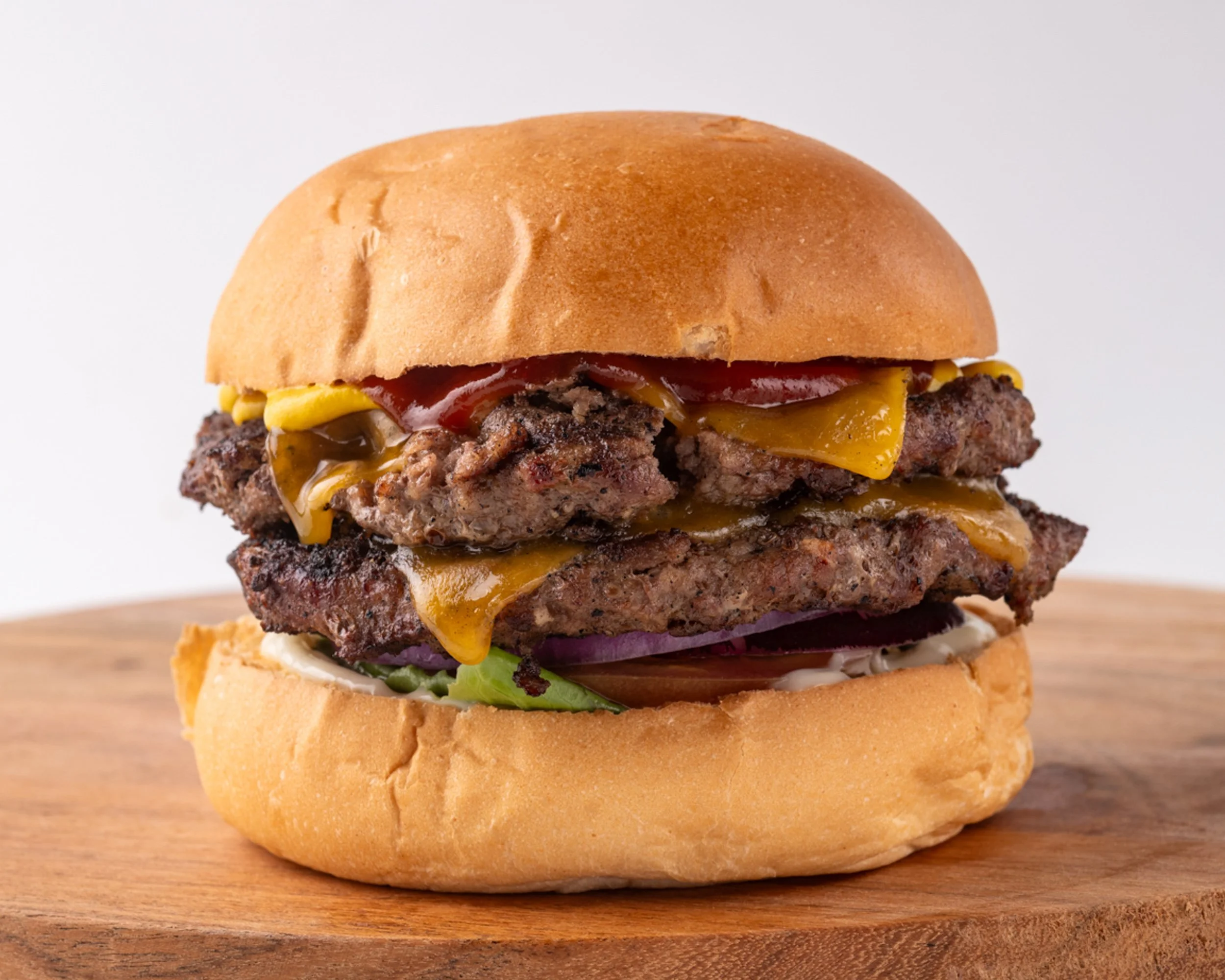 “Double cheeseburger with two beef patties, melted cheddar cheese, lettuce, onion, and sauce in a toasted bun.”