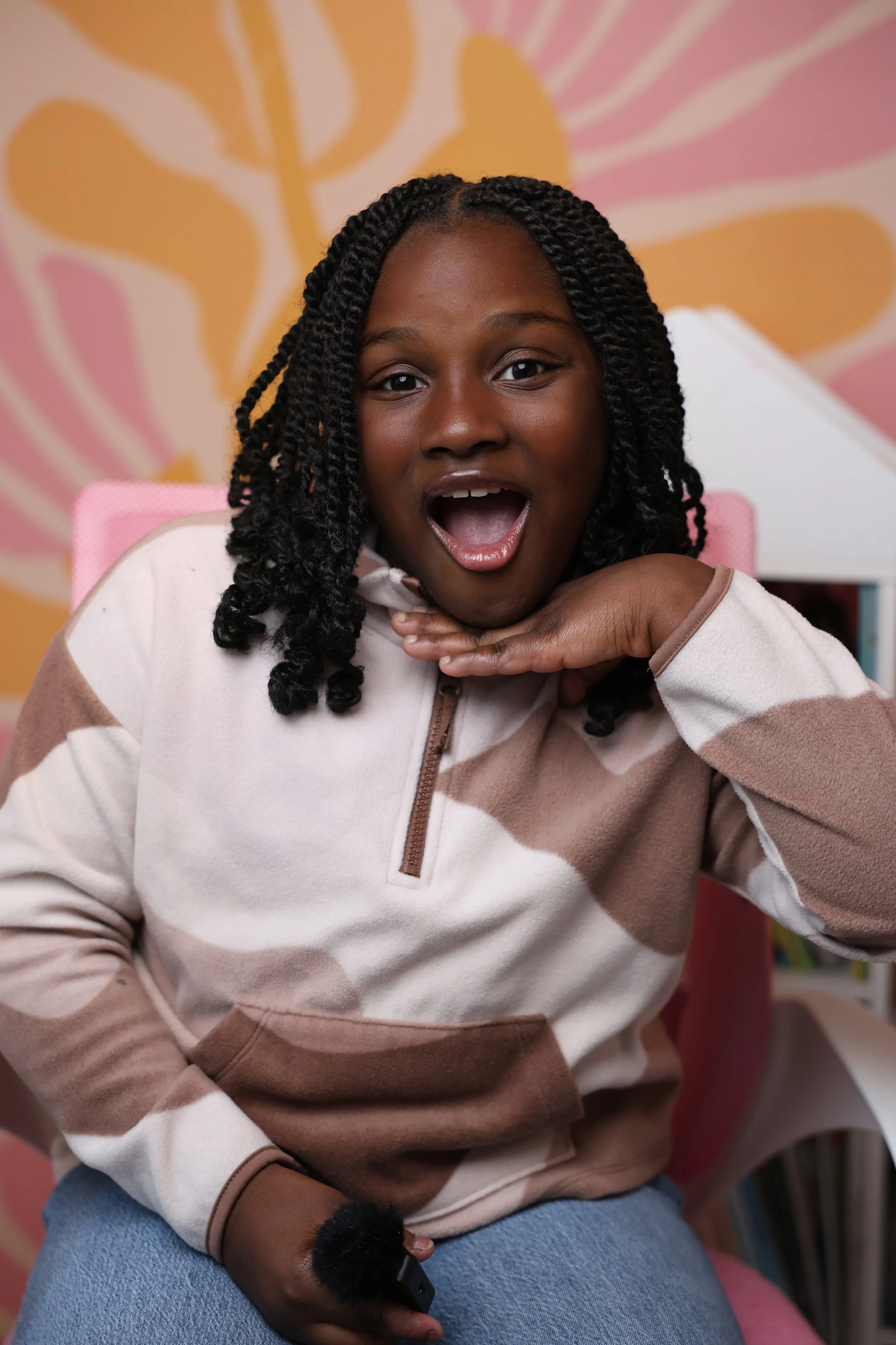 young girl smiling and posing in a abstract sweatshirt