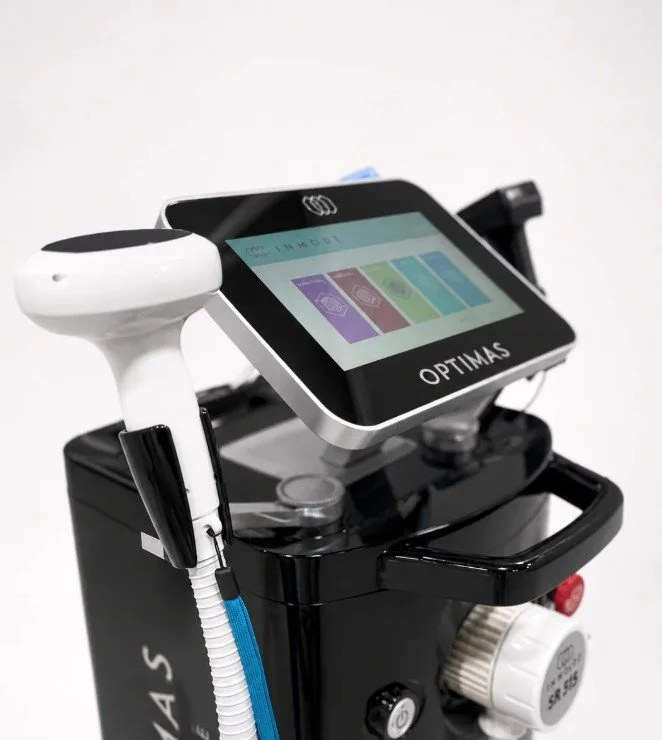 Medical device with a touch screen display labeled OPTIMAS, featuring buttons and attached tools, used for medical procedures.
