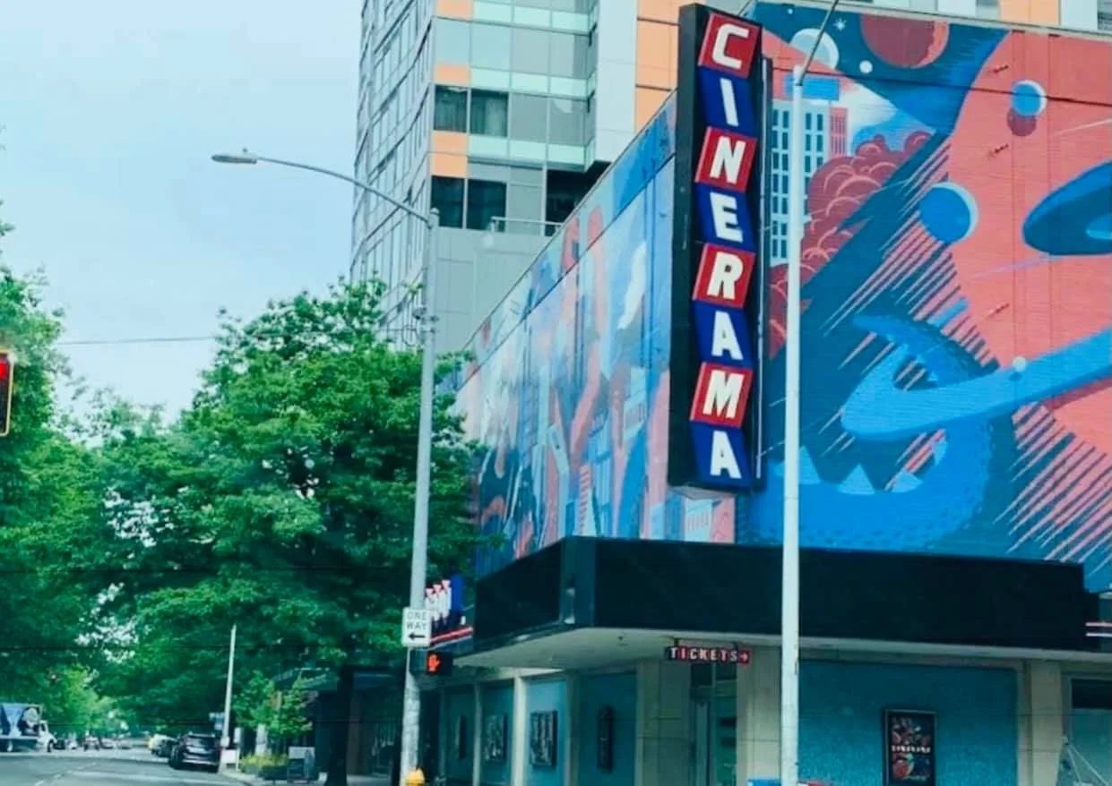The exterior of the CineRama movie theater with a vertical sign displaying