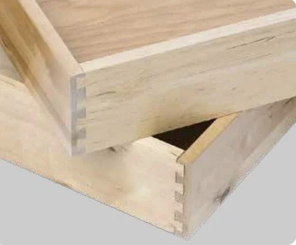 Close-up of wooden corner joint with dovetail interlocking design.