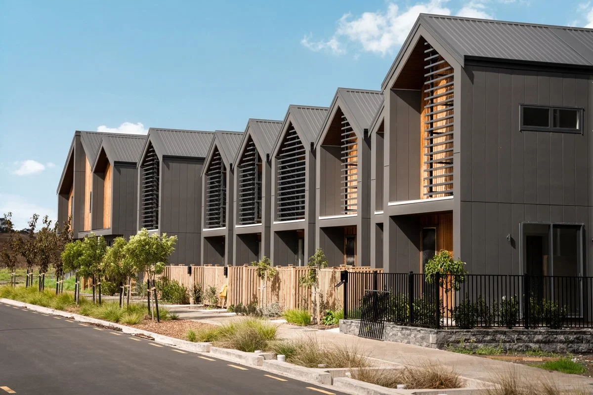 Exterior view of the Westgate residential project's multi-unit terraced housing, with distinctive dark grey and timber facade.