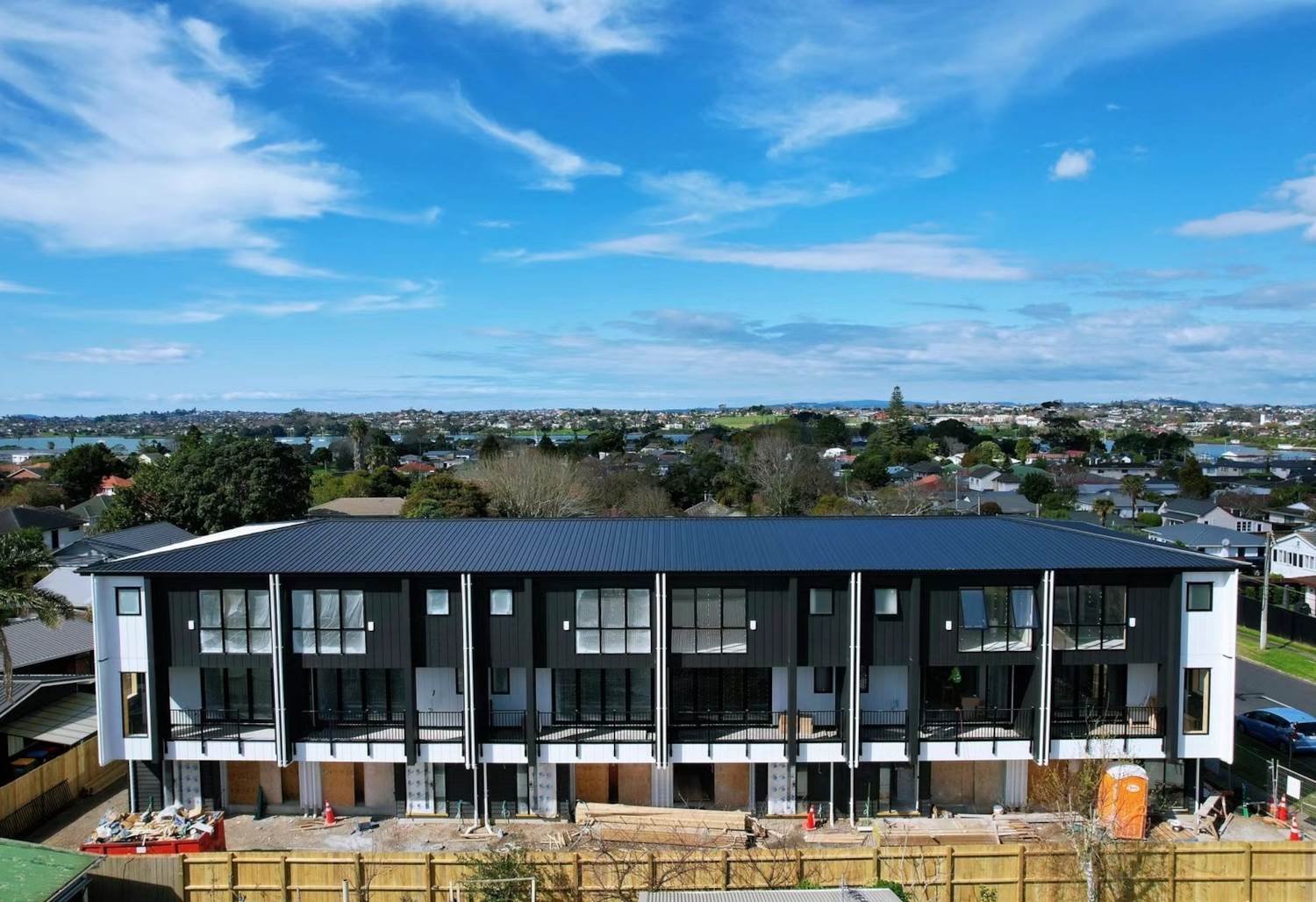 An elevated perspective of a recently completed multi-unit development of modern terraced houses in Panmure, Auckland, showcasing the architectural construction style of Wonderland Construction Group.
