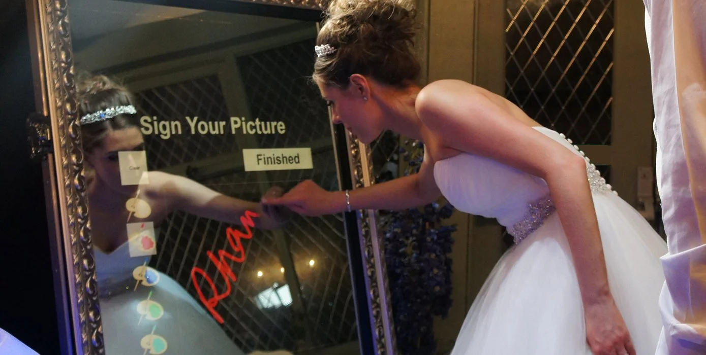 Engaged couple posing together in a photo booth at their celebration