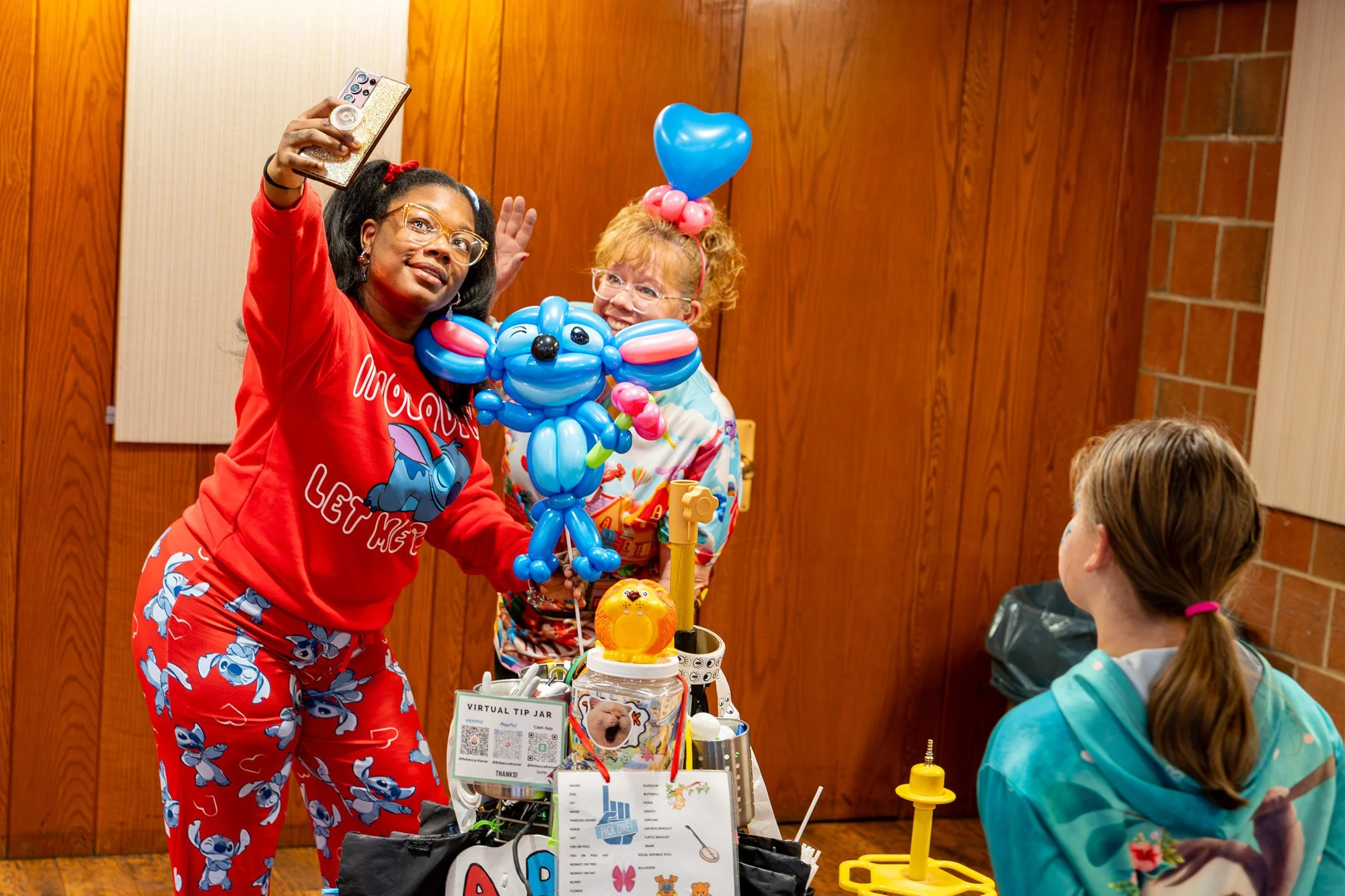 Photo of a person posing for a selfie with a balloon artist and a balloon Stitch from Disney's Lilo &amp; Stitch.