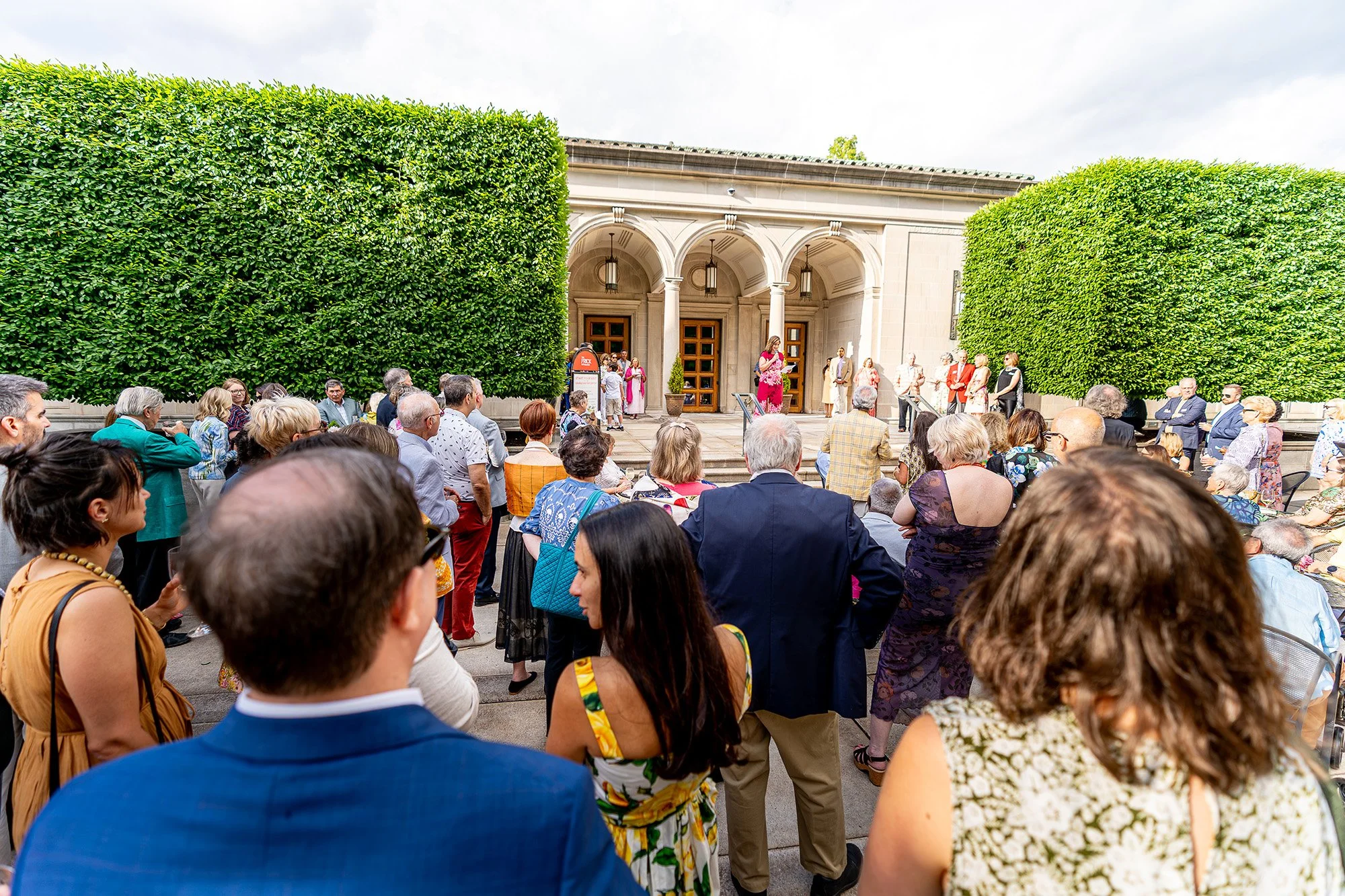 Audience gathered for an outdoor talk at a historic venue.