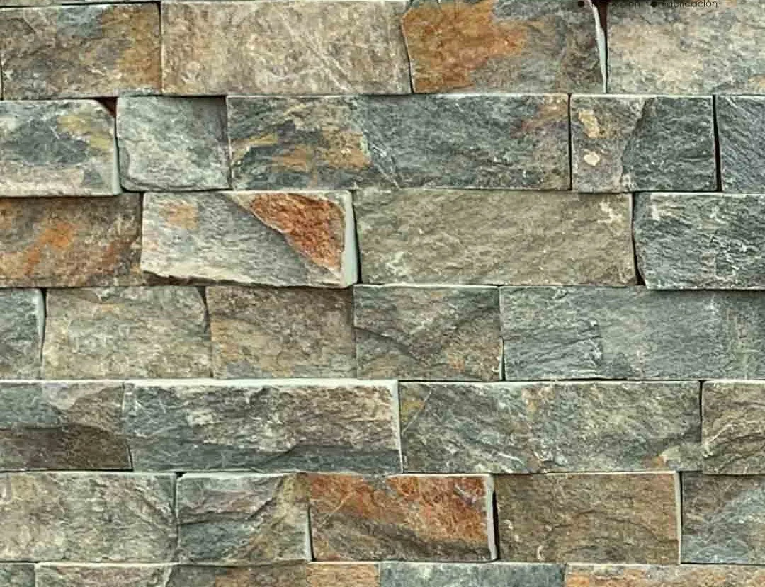 Muro de piedra decorativa con bloques en tonos grises y marrónes.