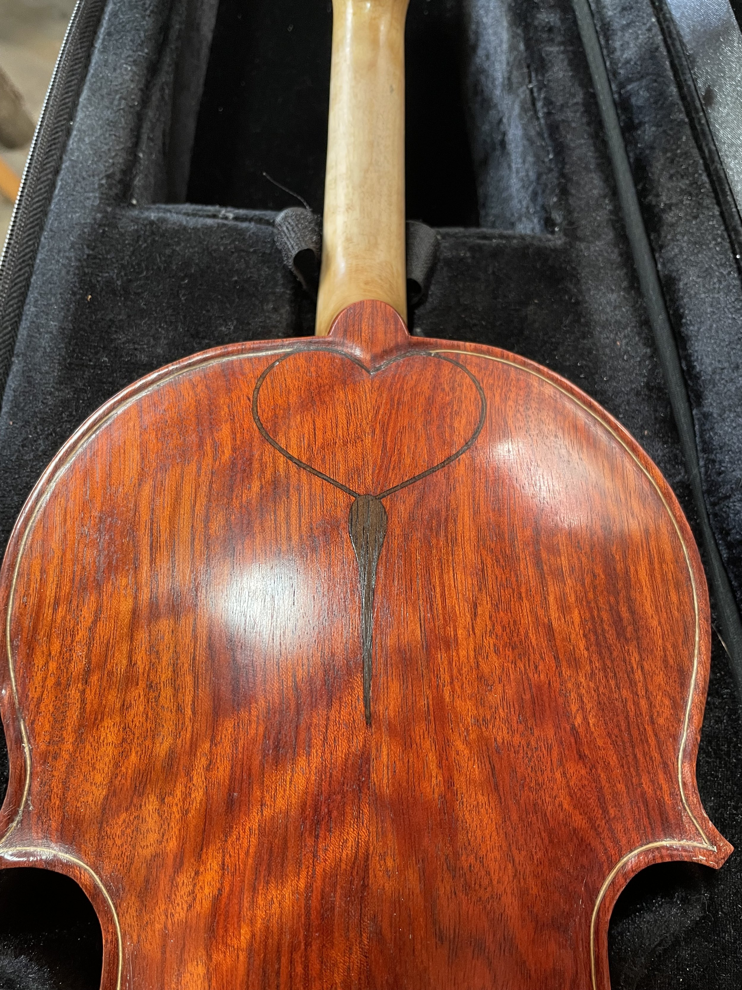The upper back shows the bloodwood in closer detail, with the inlay used not as ornament alone, but as part of the instrument’s visual order.