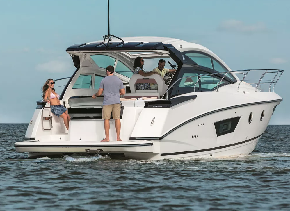 A group of four people enjoying a day on a white yacht sailing on the water under a partly cloudy sky.