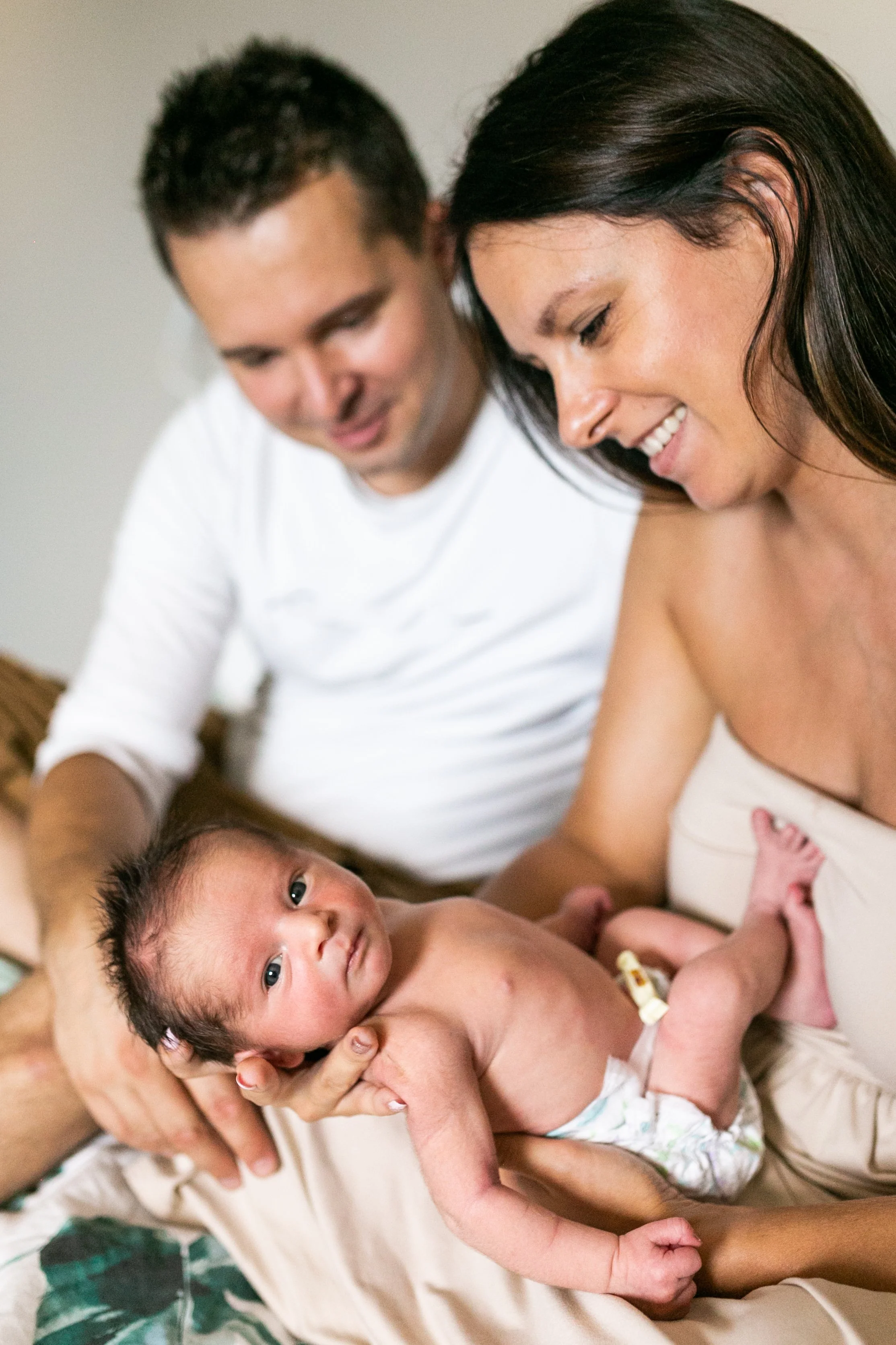 A couple looking at their newborn baby.