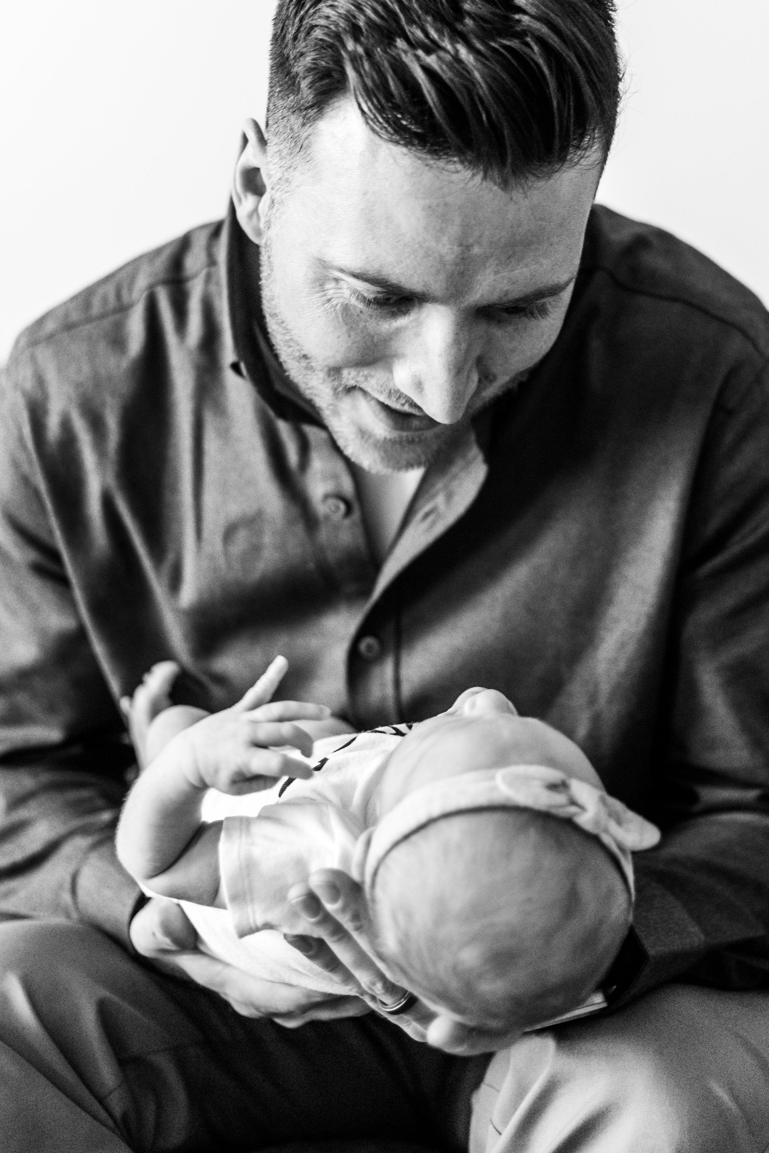 Black and white photo of a man holding an infant.