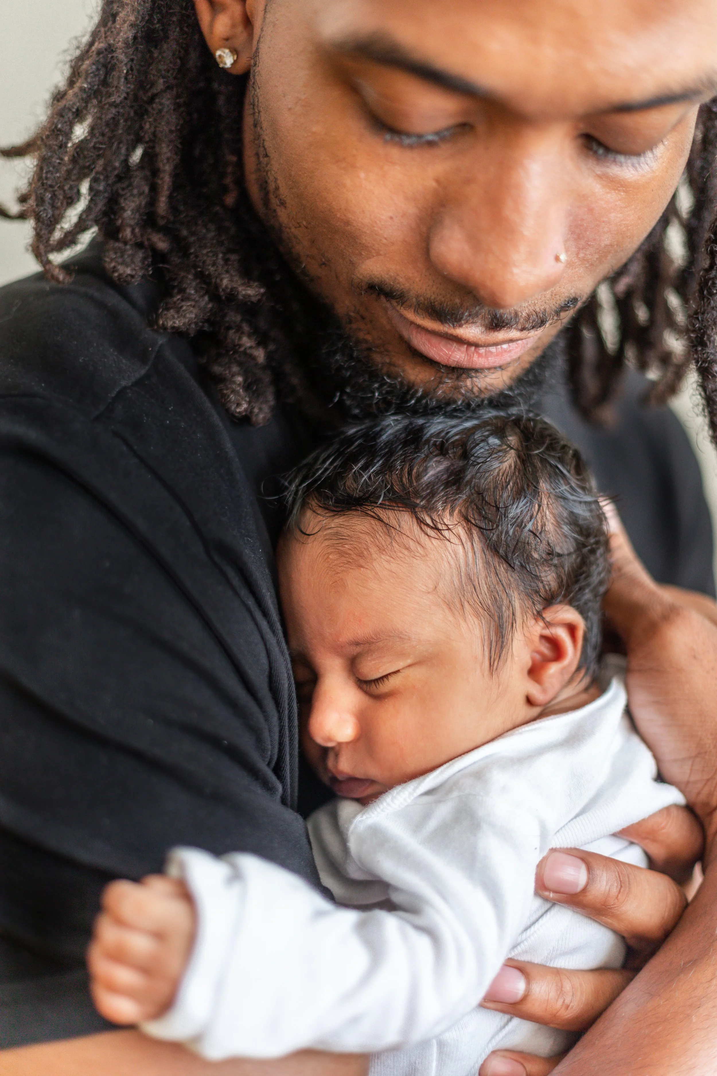 Person gently holding a sleeping baby.