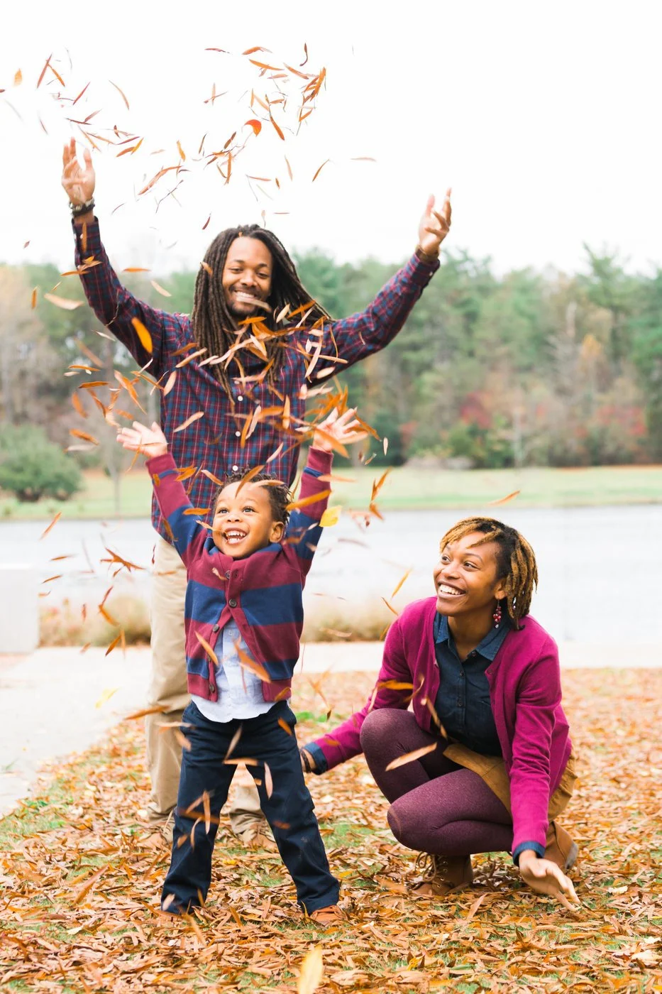 Family playing with autumn leaves outdoors
