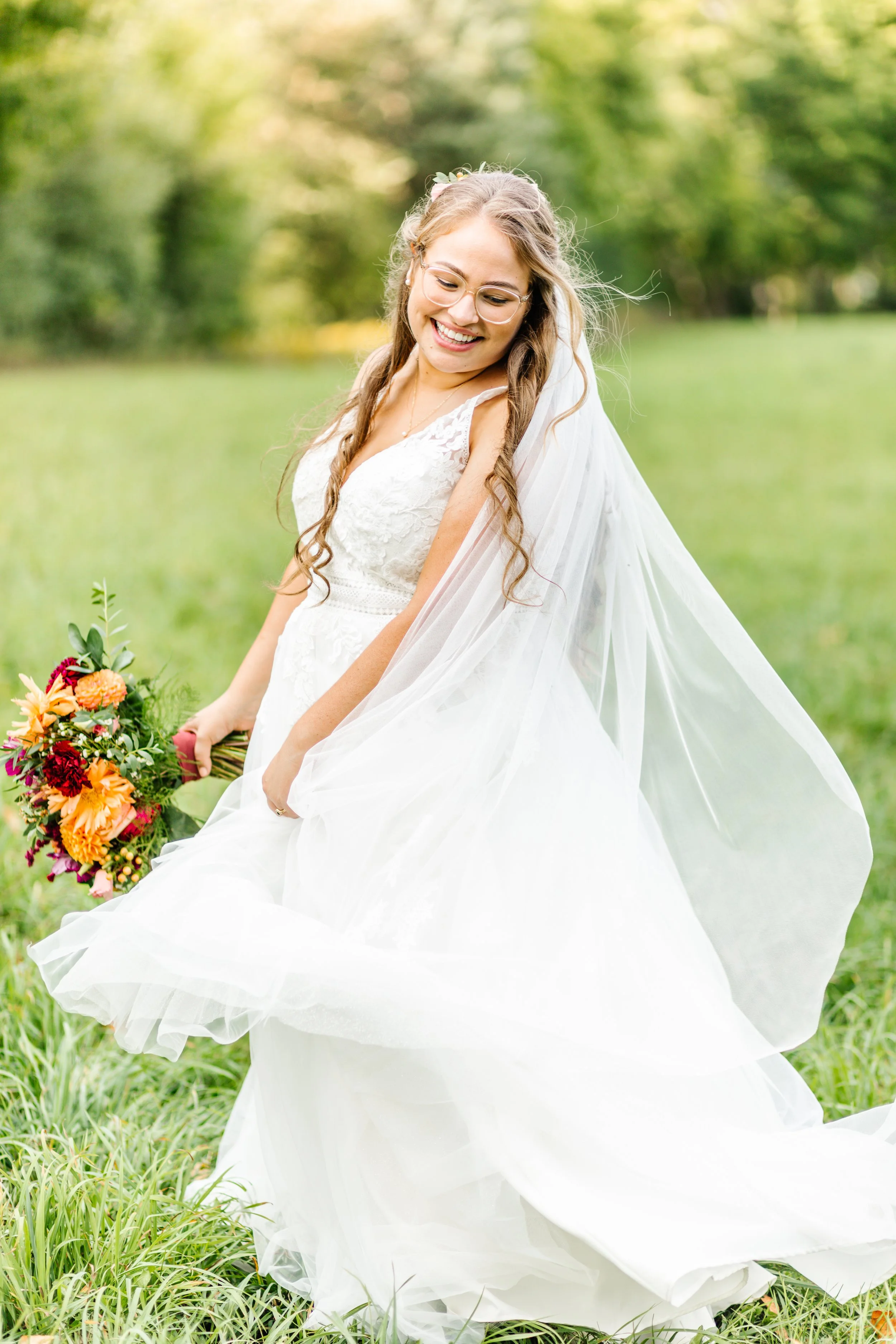 Bride in white wedding dress holding colorful bouquet in outdoor setting