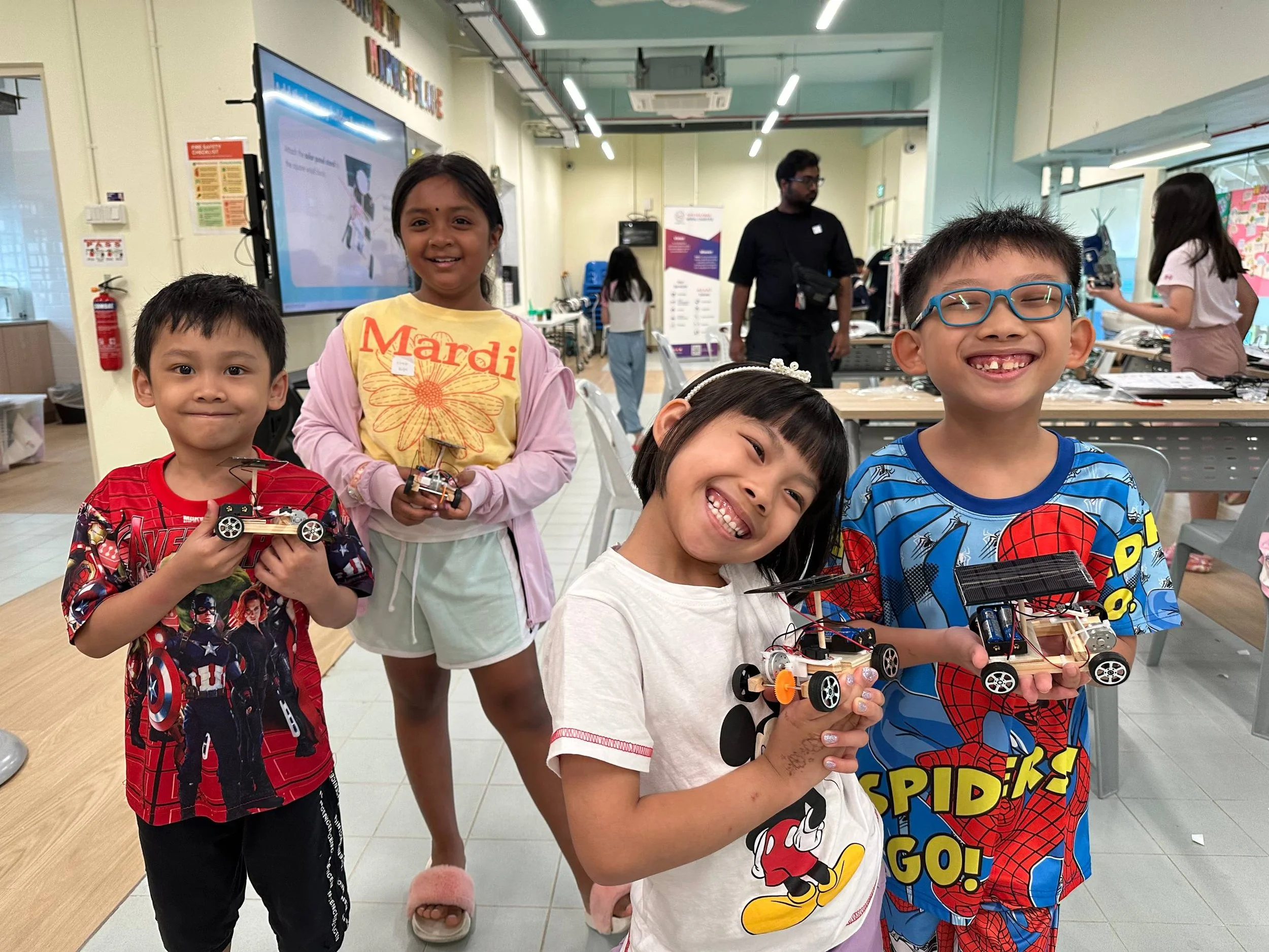 Children from THK showing their solar cars built during a sponsored STEM program