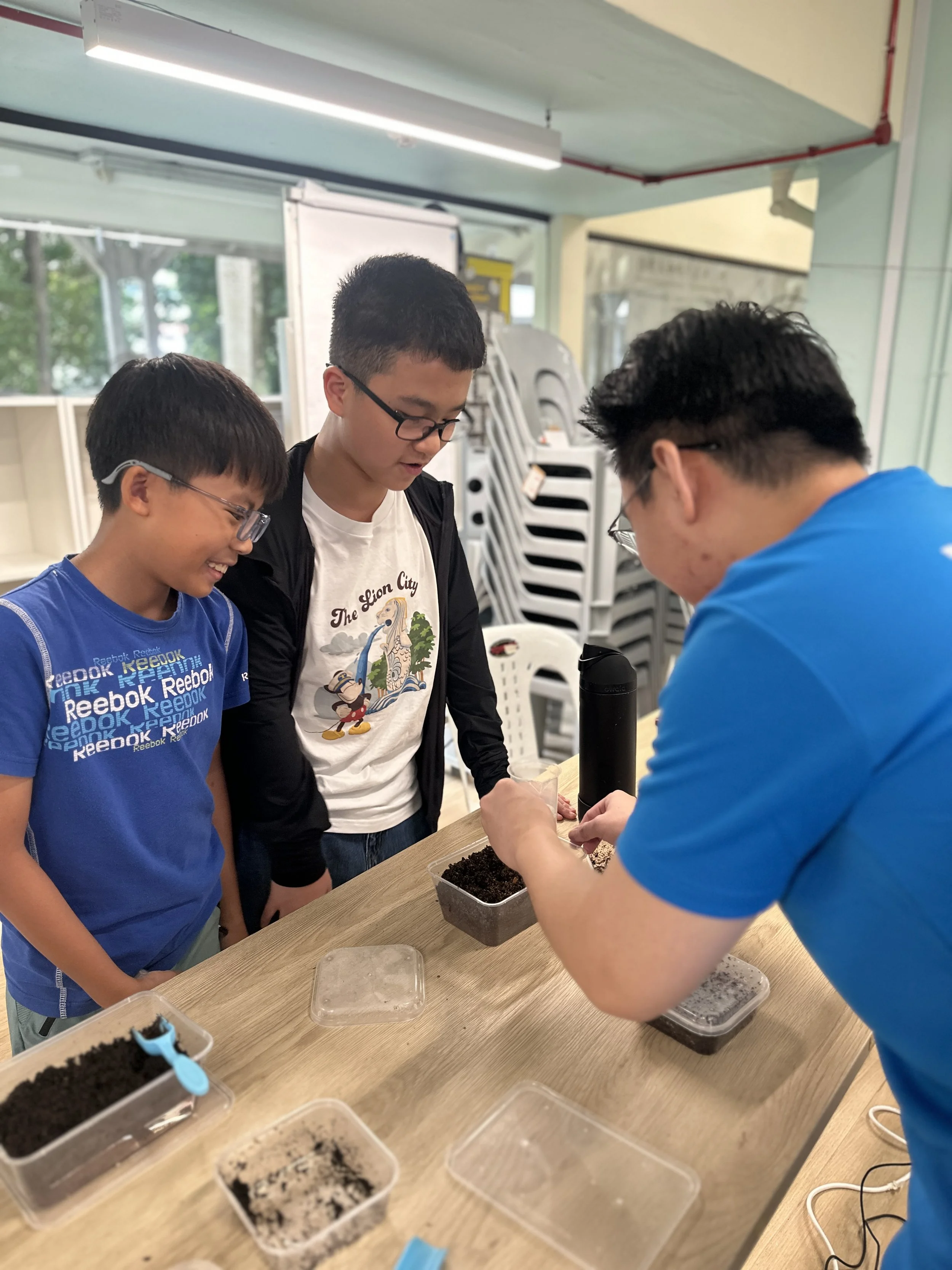 Facilitator guiding students through a hands-on composting and soil activity at an EcoVenturers workshop