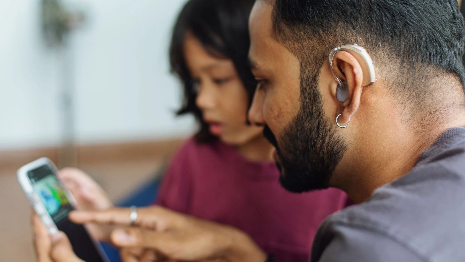 Father and child looking at a mobile game screen together