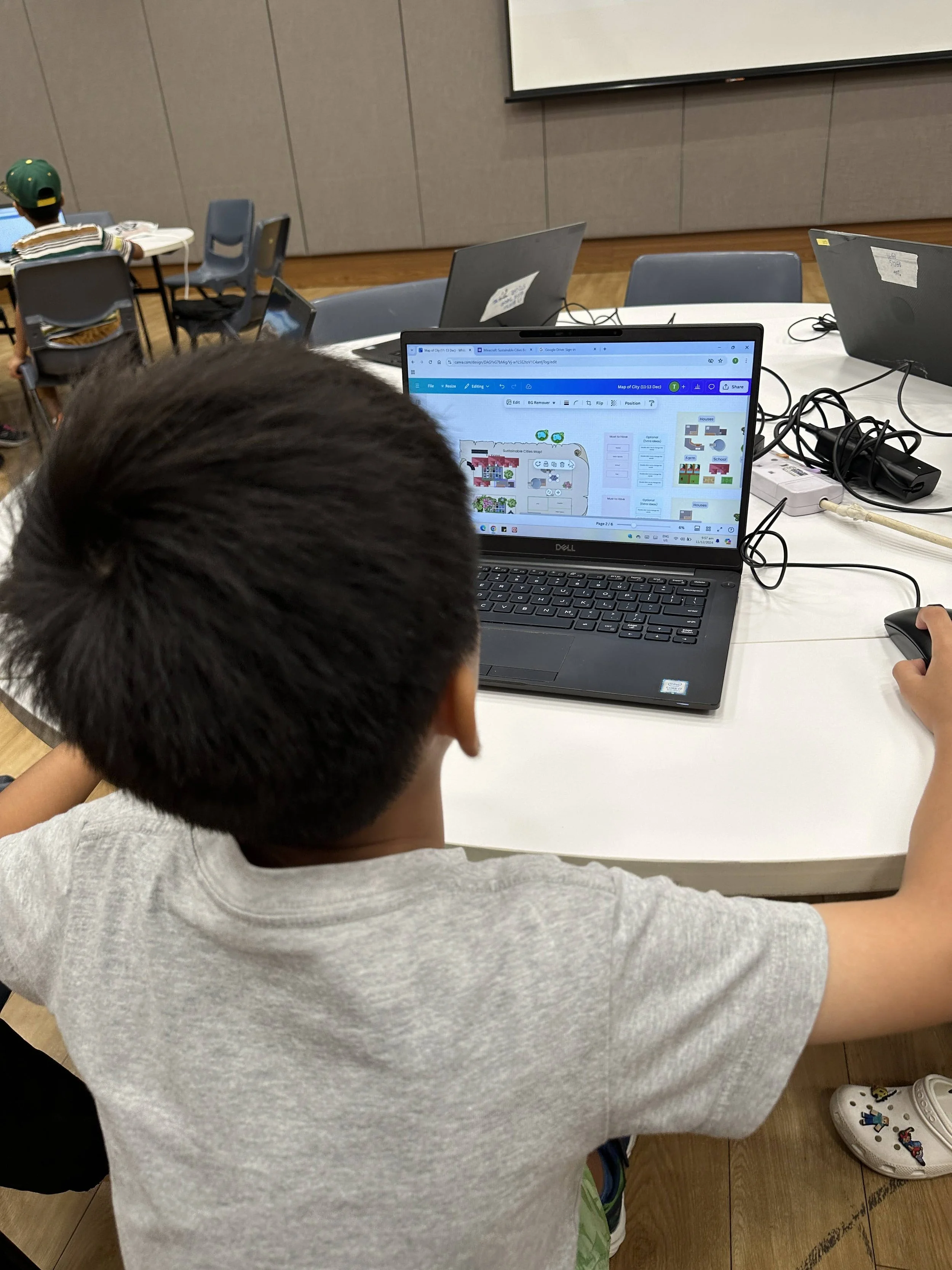 Primary school boy preparing Canva presentation for his project