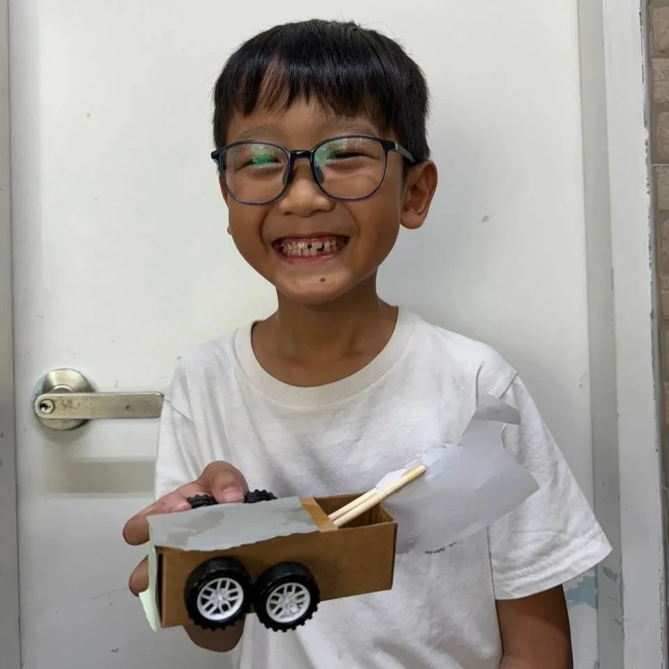 happy boy holding to his project cardboard car