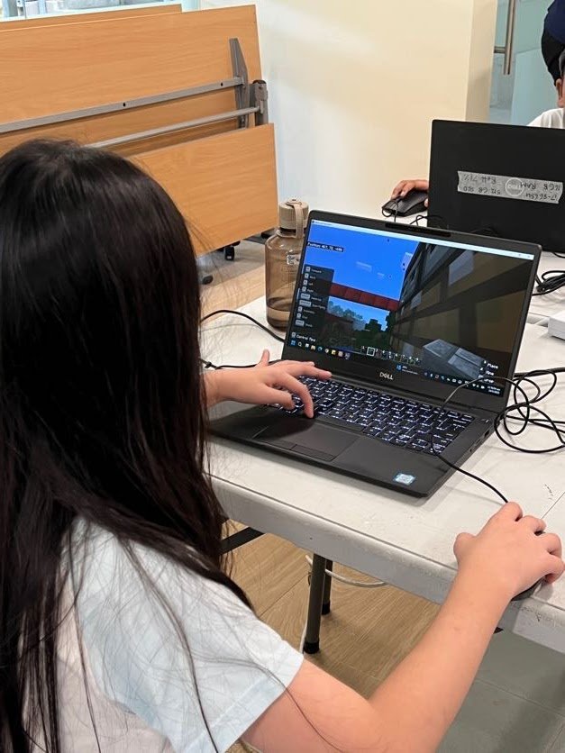 Child building a sustainable virtual city in Minecraft Education Edition during an EcoVenturers workshop