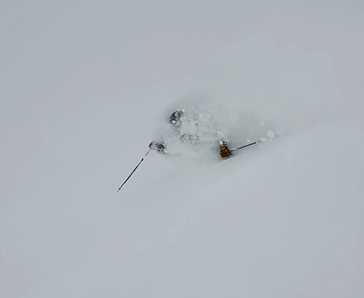 Two skiers in deep powder snow on a snow-covered mountain slope.