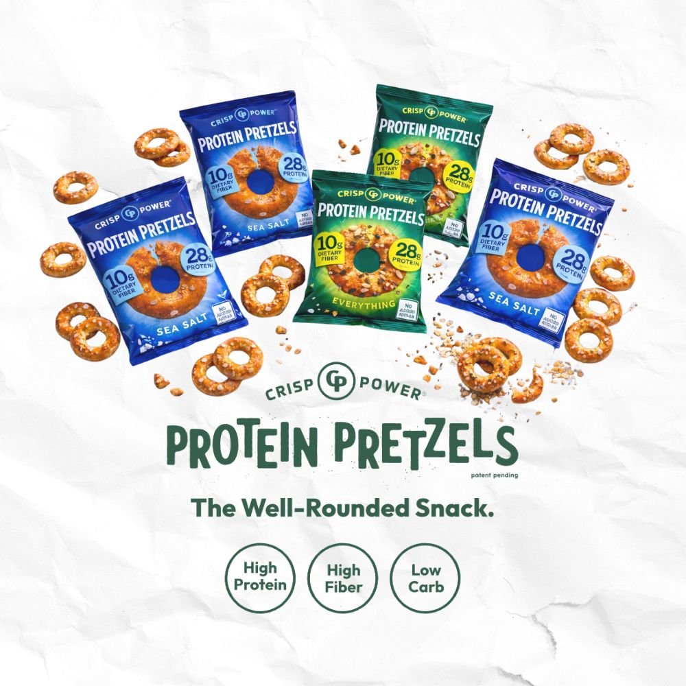 Various packages of protein pretzels are displayed on a white surface, with some pretzels scattered around. The packages are labeled sea salt, everything, and sesame, and highlight features like high protein, high fiber, and low carb.