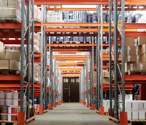 Warehouse aisle with shelves stocked with containers and boxes on industrial metal racks.