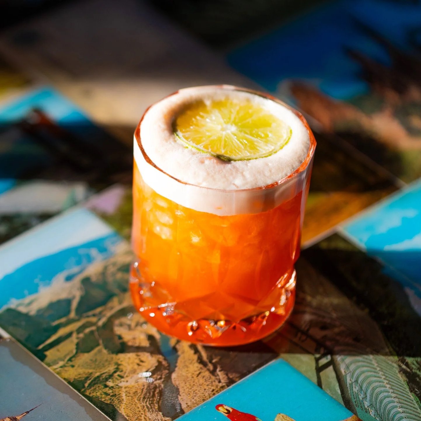 A bright Orange Cocktail in a lowball Glass