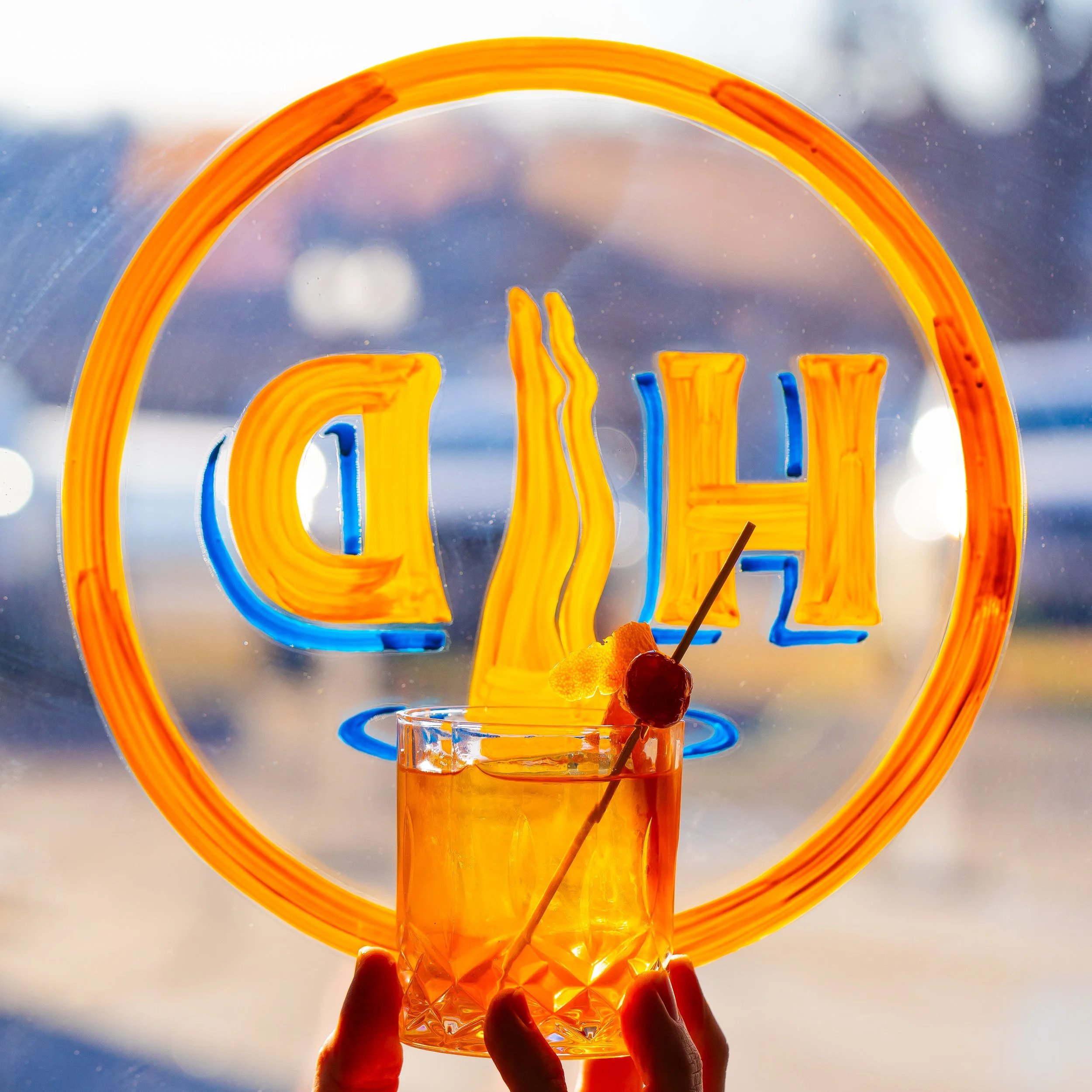 An old fashioned in front of a beautiful hand painted sign