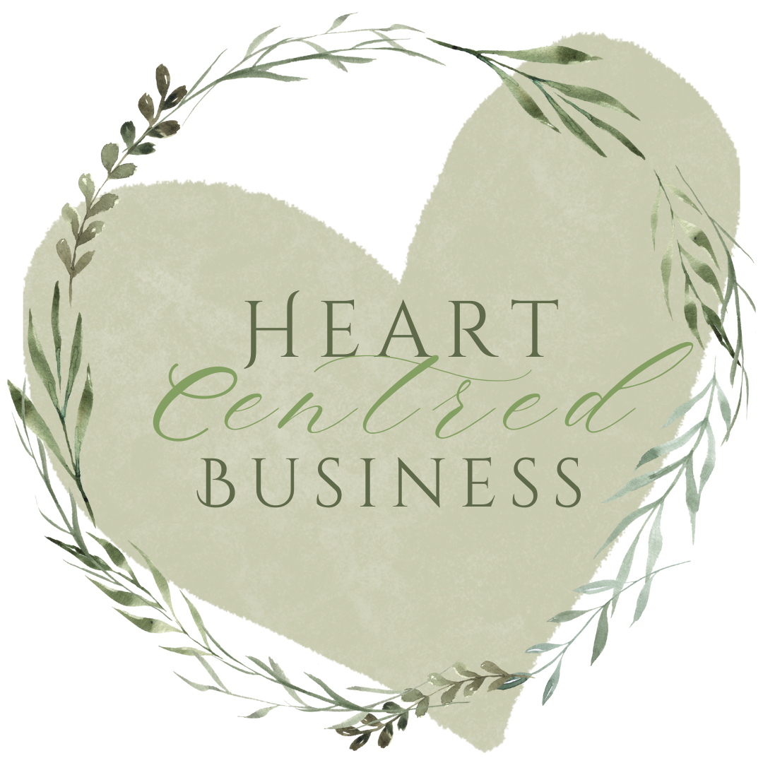 A soft watercolor illustration of a heart surrounded by a wreath of leafy branches with the words "Heart Centered Business" written inside.