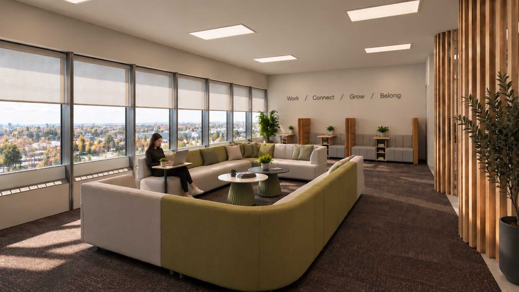 Modern lounge area with large windows, a woman working on a laptop, sectional sofa, coffee tables, potted plants, and motivational words on the wall: Work, Connect, Grow, Belong.
