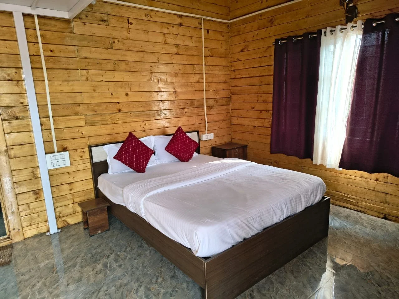 "Wooden cottage bedroom at Wild Monk Dandeli jungle stay resort with comfortable bed and nature view"