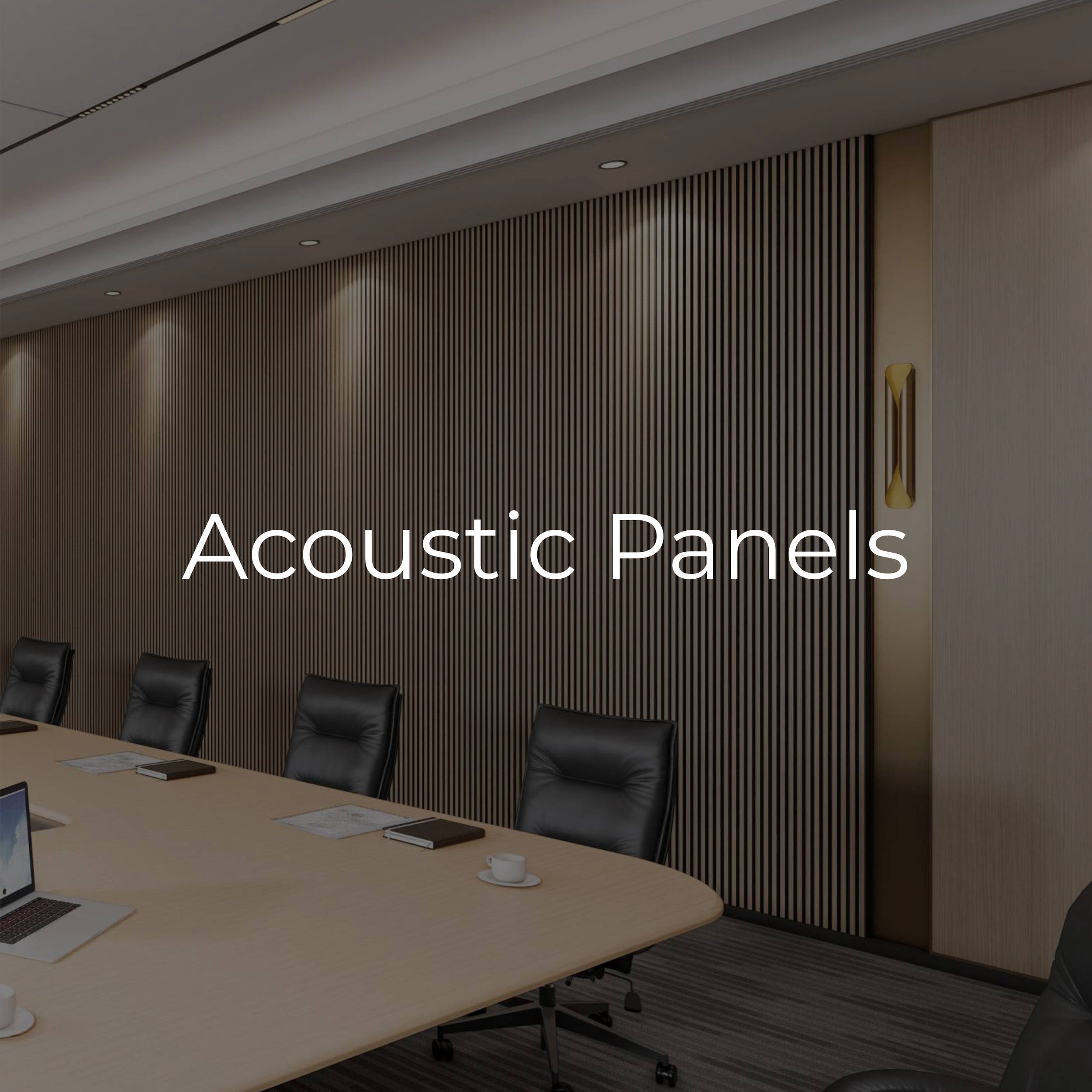 Conference room with acoustic panels on the wall, black leather chairs, laptops, notebooks, and cups on the table.