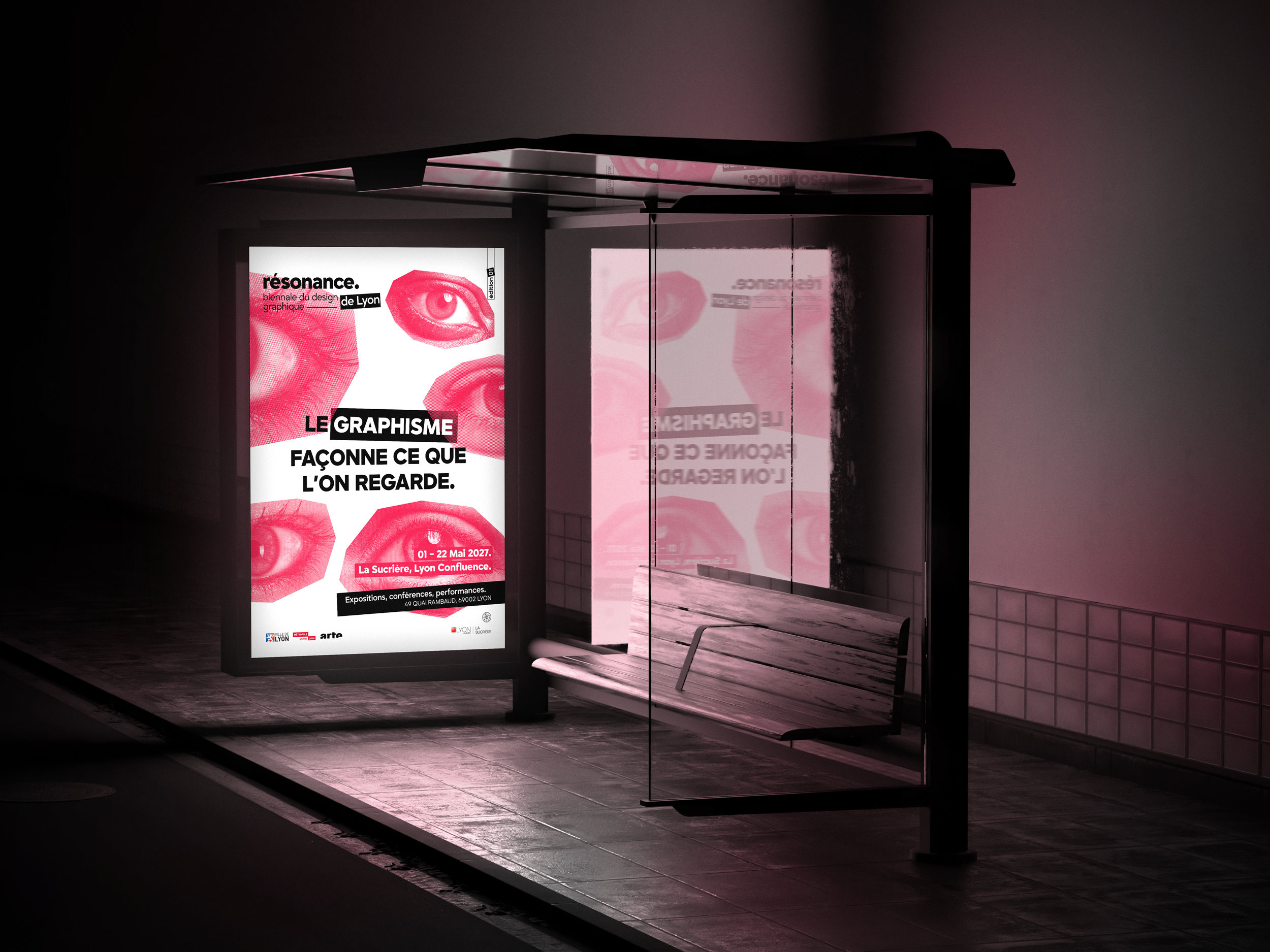 Affiche publicitaire pour un événement de design graphique avec des images de yeux rouges et le texte en français, situé dans un abri bus la nuit.
