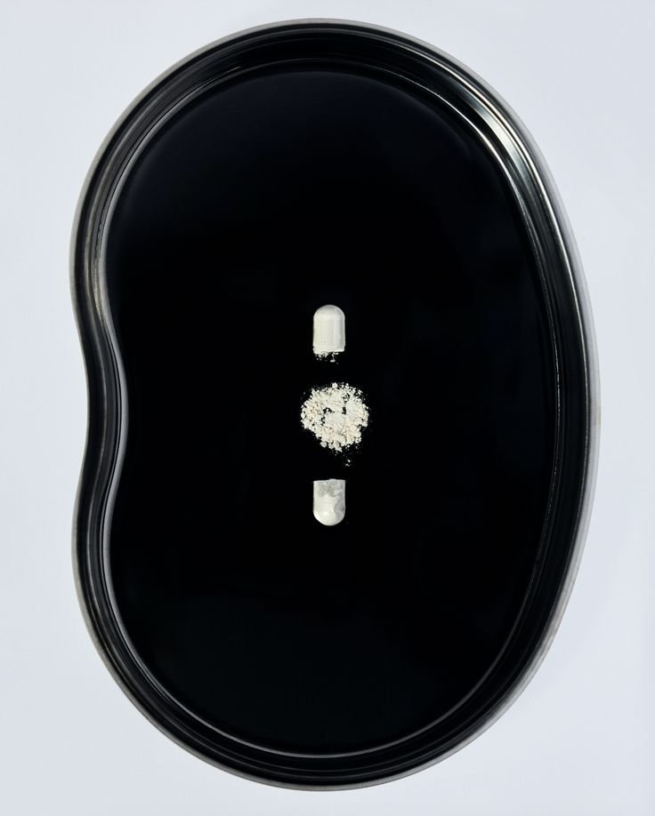 Supplement capsule and powder on a black plate