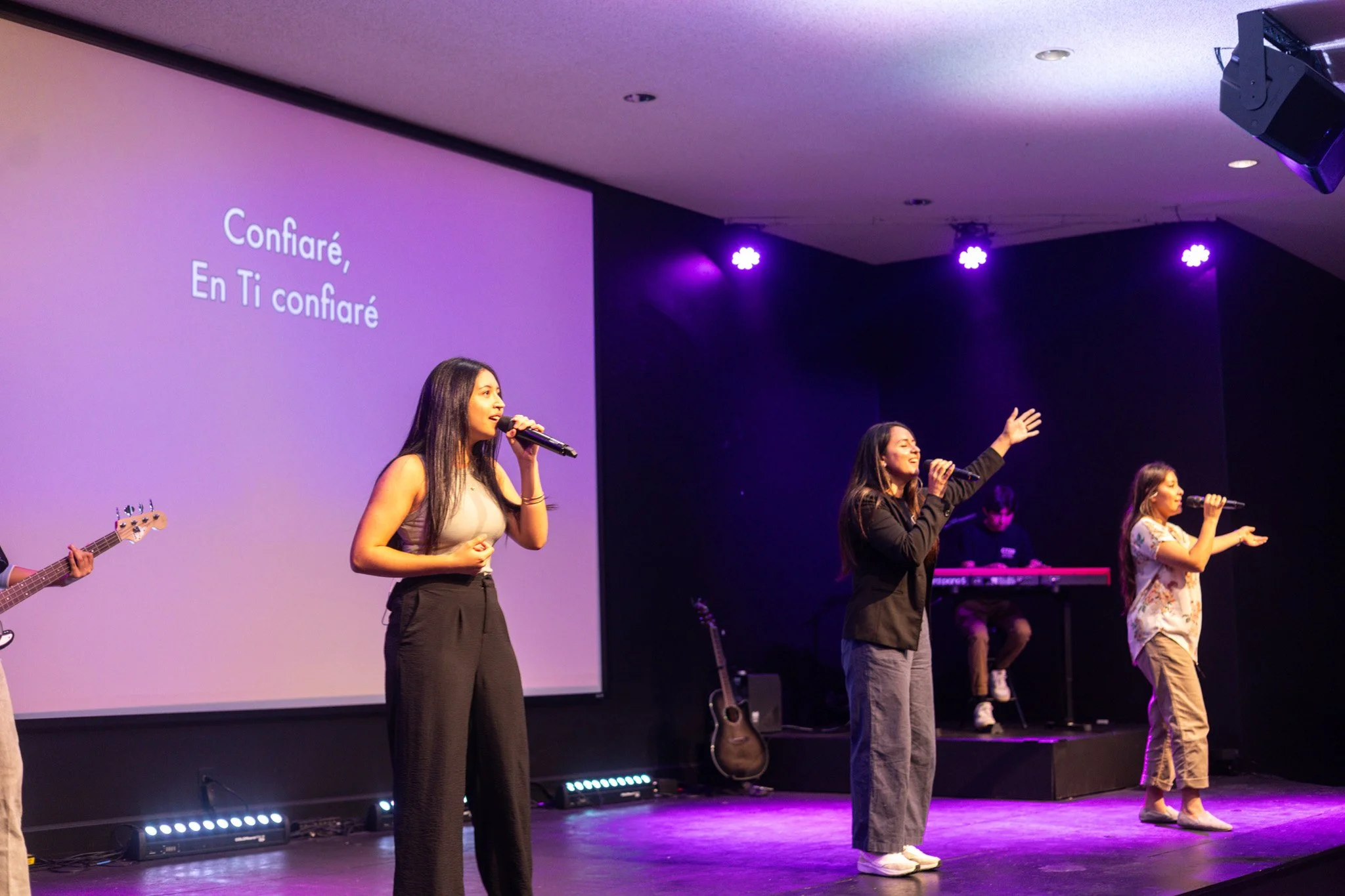 Rendering of the future Citizen Church West building with people walking in the parking lot, cars parked, and trees around, under a partly cloudy sky.