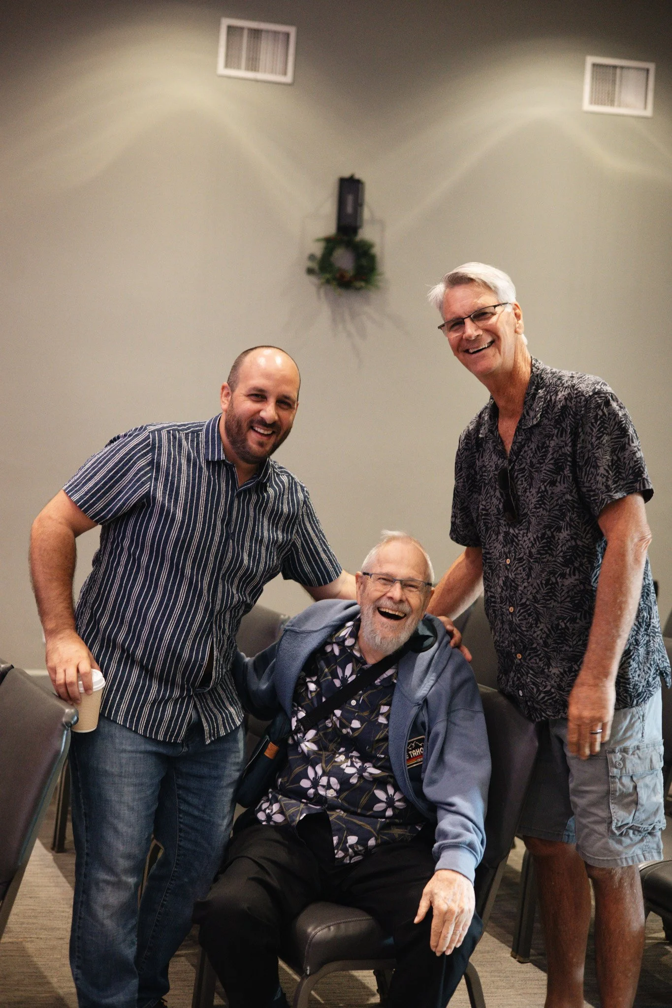 A group of people sitting in a circle at an outdoor event or workshop near a cafe or restaurant.