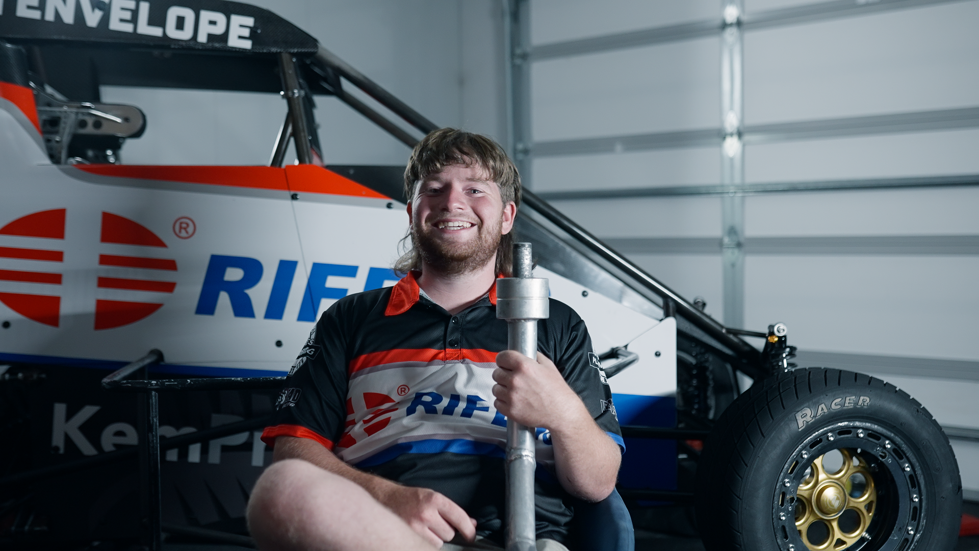 Young man smiling as he's being interviewed about his passion for Speedway Racing in New Zealand while wearing his Crew Shirt with pride