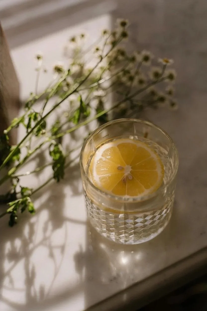Fresh lemon herbal drink with greenery symbolising natural digestive health and holistic nutrition guidance from Naturally Nourished Nutrition in Tasmania.