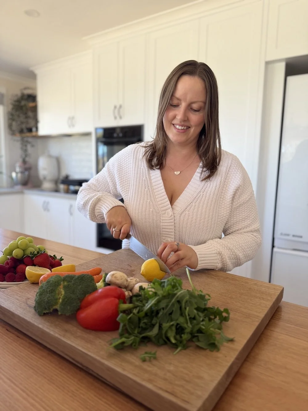 Laura Duncombe preparing fresh vegetables in kitchen, Clinical Nutritionist at Naturally Nourished Nutrition supporting digestion, energy and women’s health in Tasmania.