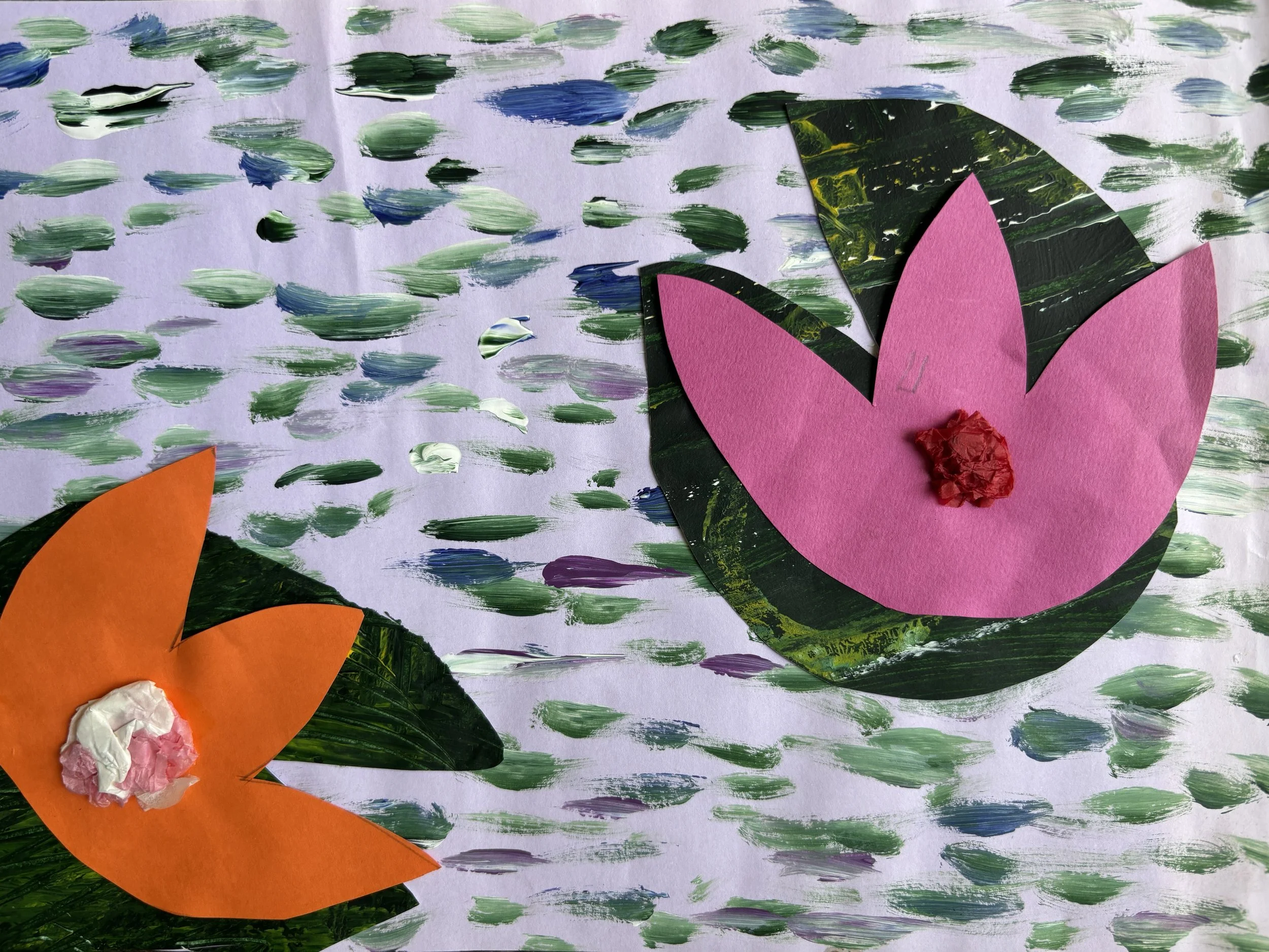 Colorful paper craft of two flowers with pink and orange petals, set against a background of painted green and purple brushstrokes on paper.